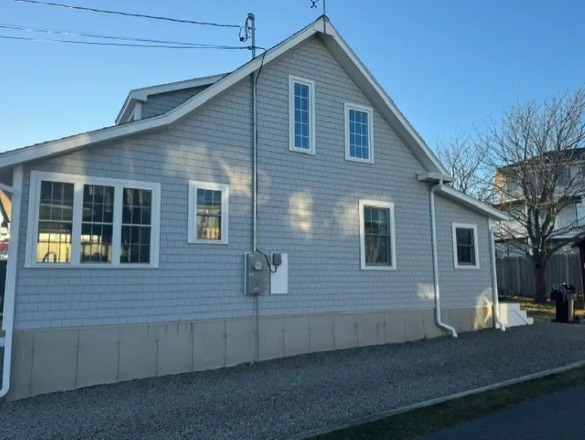 A large white house with black shutters and stairs