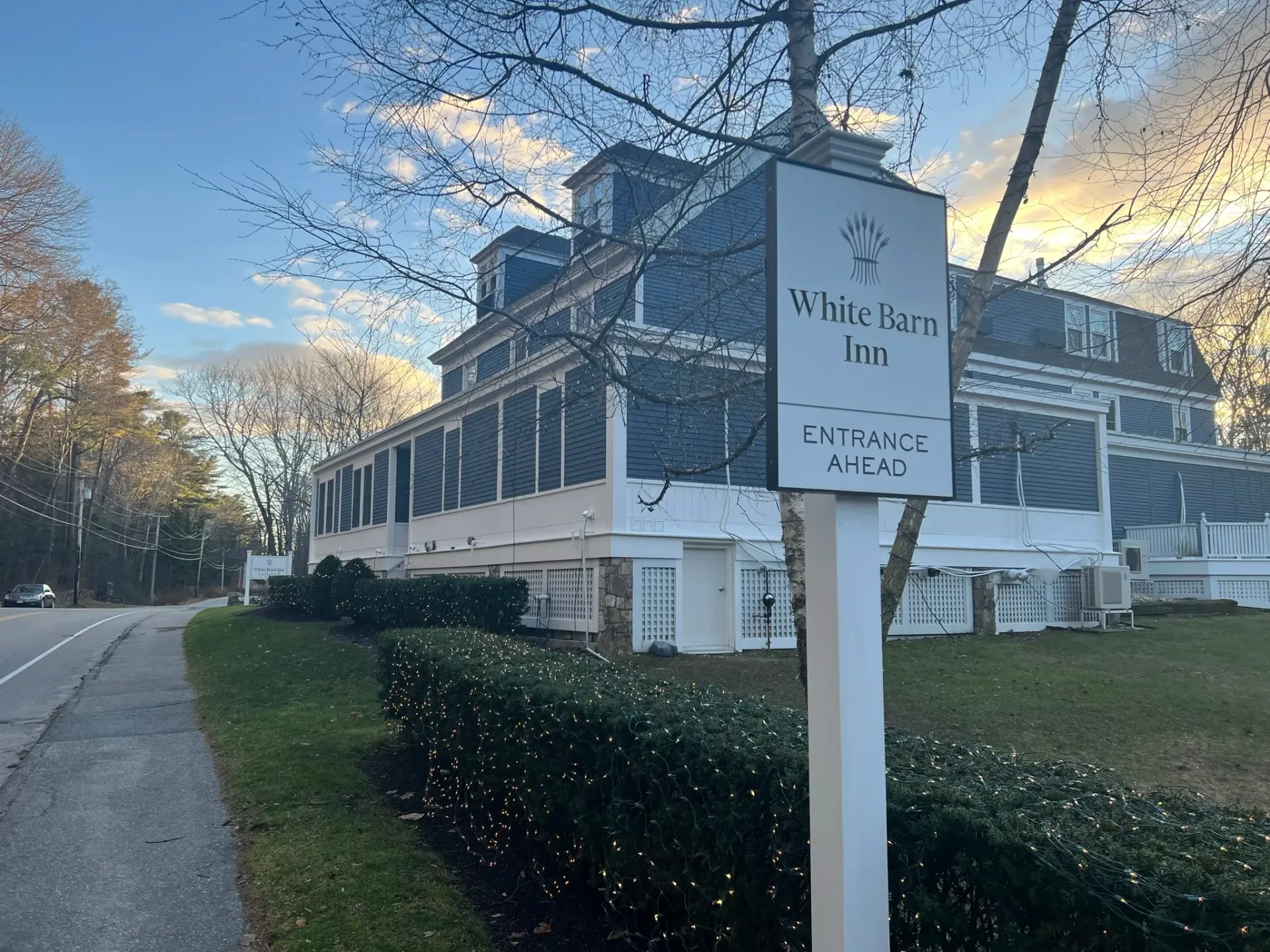 A large white building with a white sign in front of it.