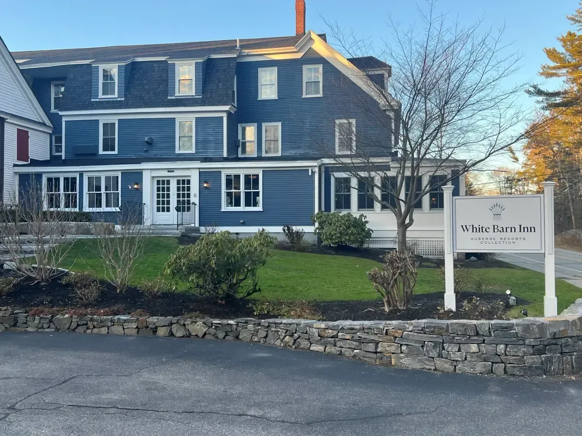 A large blue house with a white sign in front of it