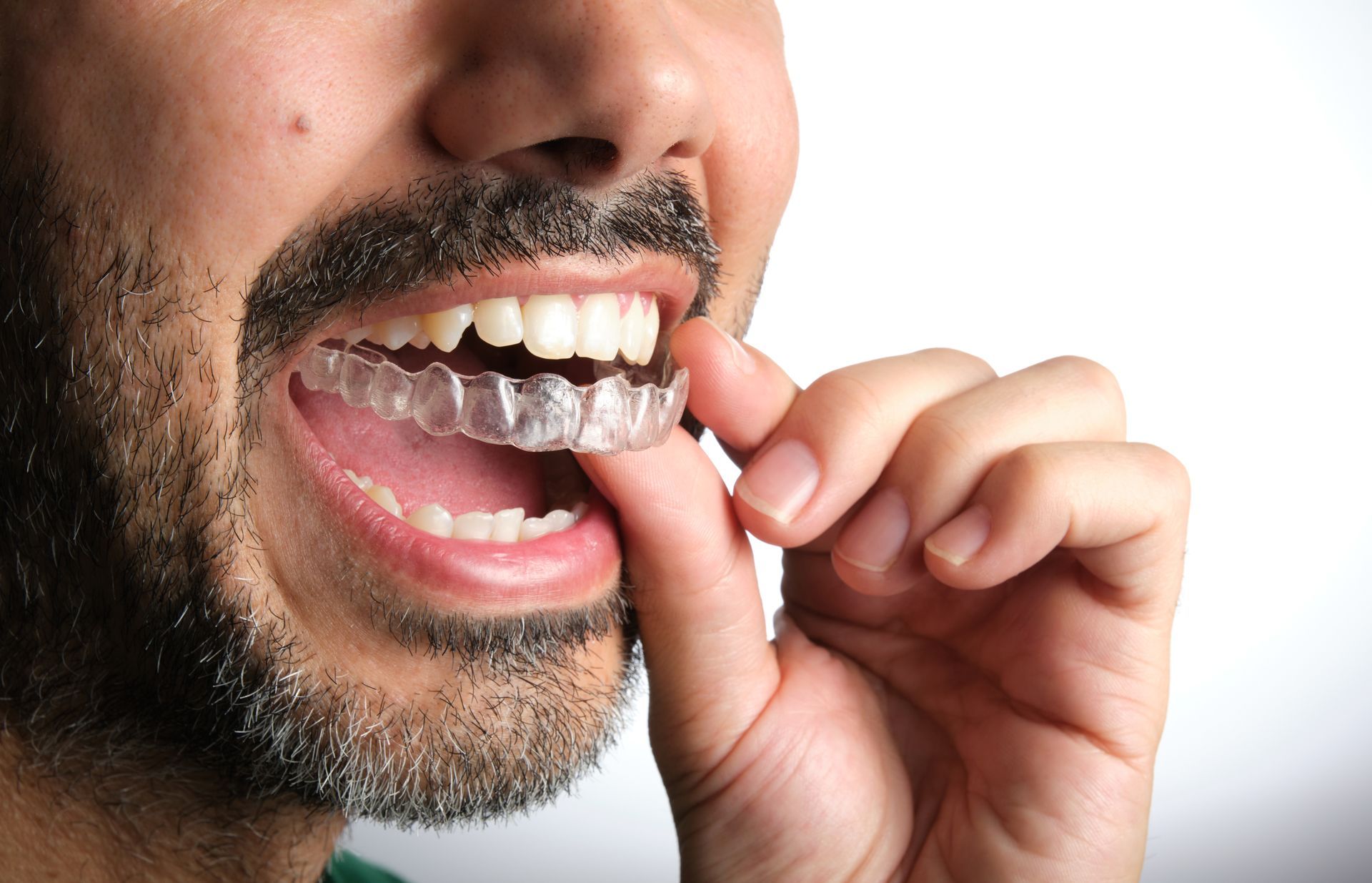 Person flossing teeth with a strand of clear dental floss, close-up of mouth and hand