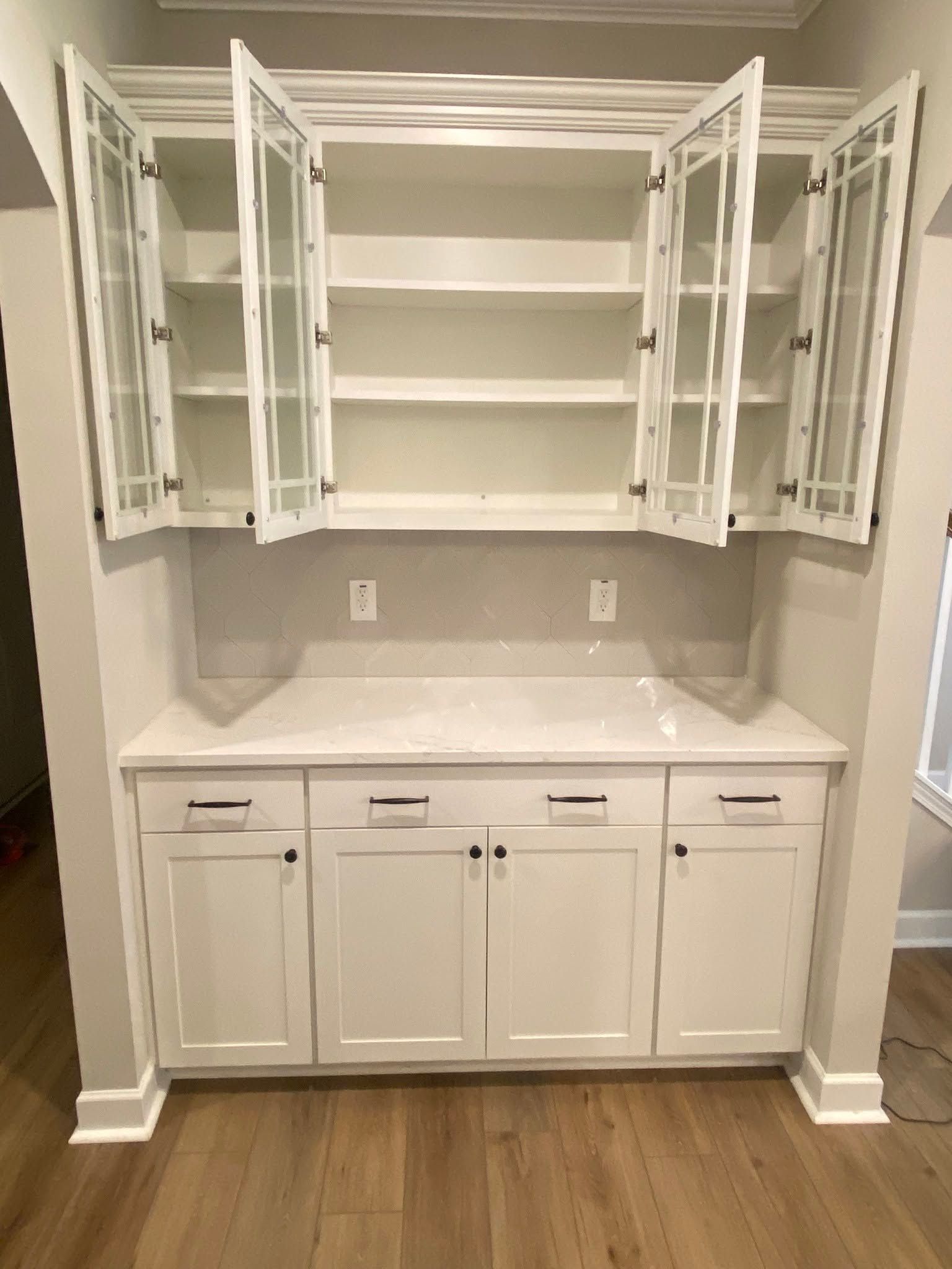 White laundry room cabinet wall with open upper cabinets, countertop, sink, and lower cabinets.