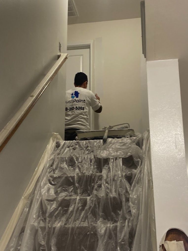 Person carrying furniture up a stairwell wrapped in protective plastic
