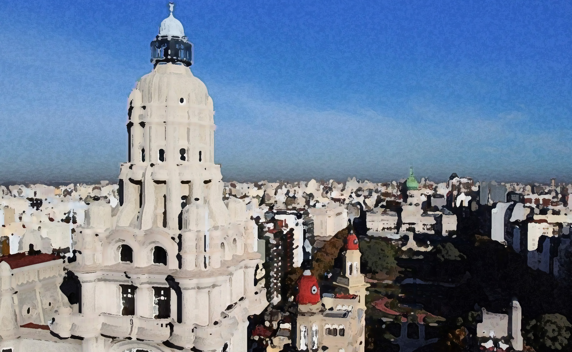 Una blanca torre de iglesia se alza sobre el denso horizonte de la ciudad bajo un cielo azul despejado.