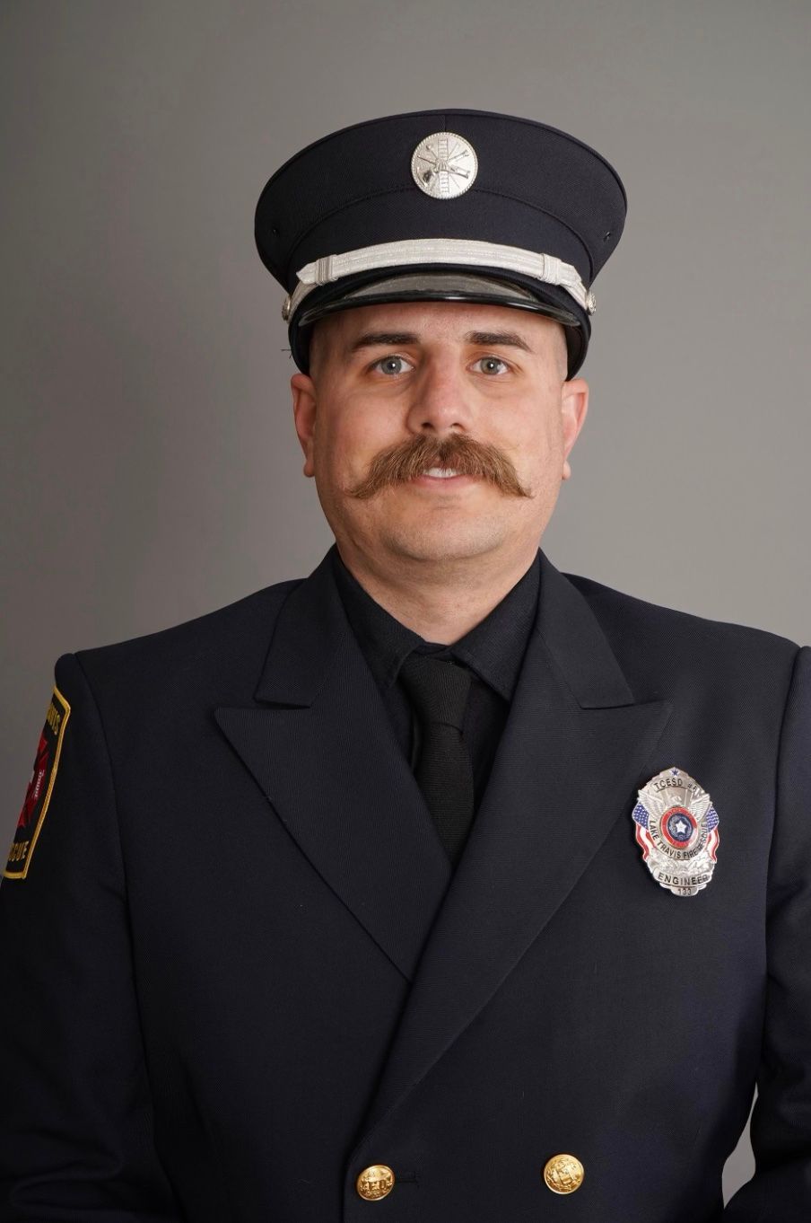 A man with a mustache is wearing a police uniform