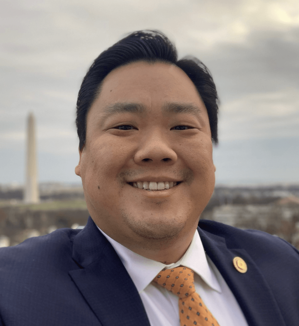 A man in a suit and tie is smiling for the camera.