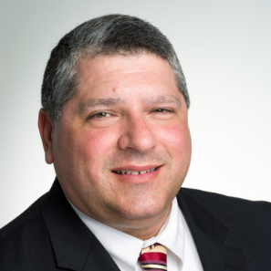 A man in a suit and tie smiles for the camera