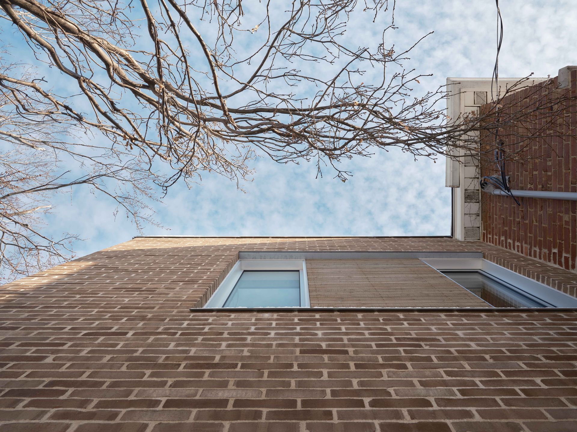 Regardant un bâtiment en briques avec un arbre en arrière-plan.