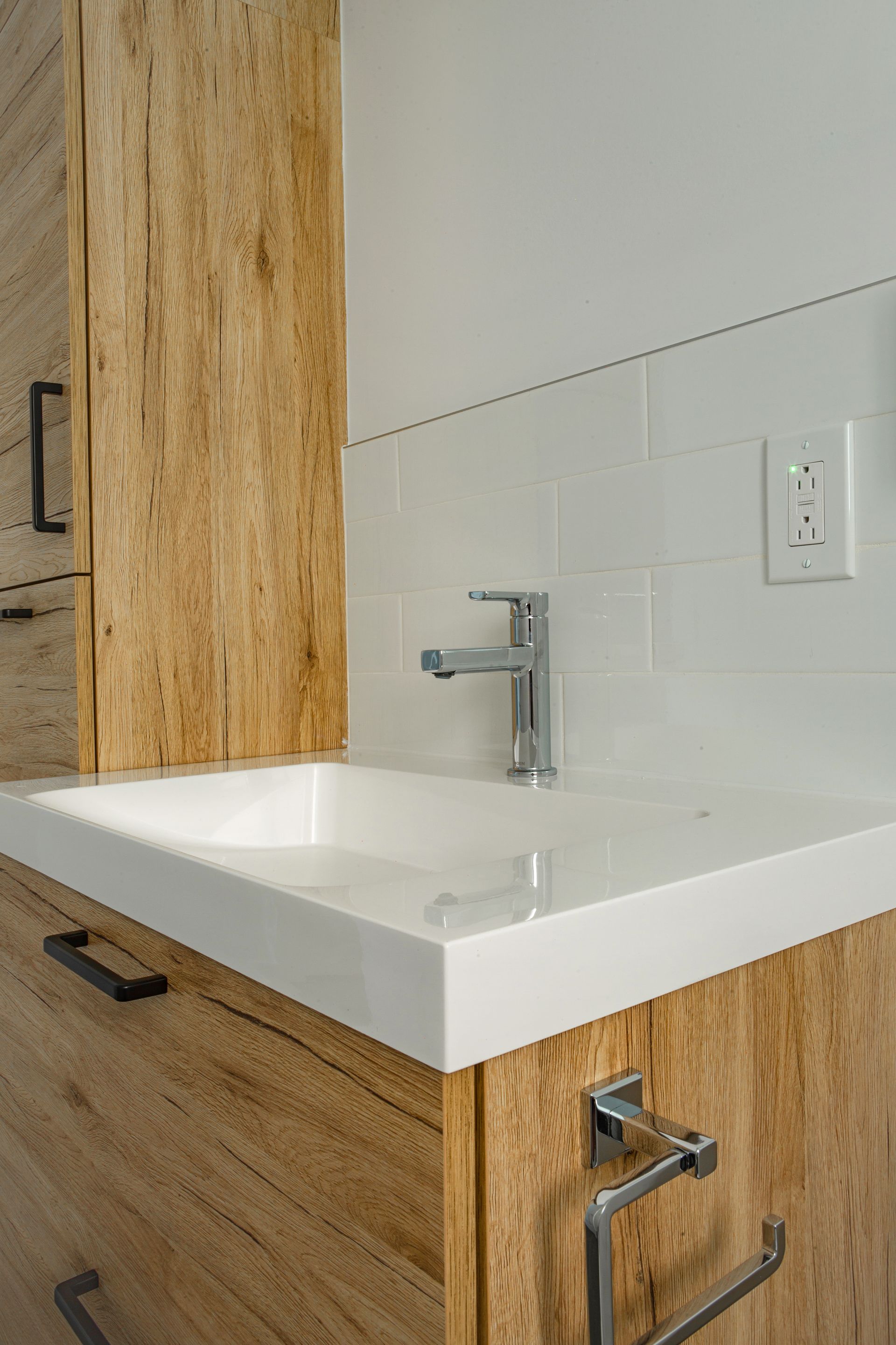 Un lavabo de salle de bain avec un robinet et des armoires en bois.