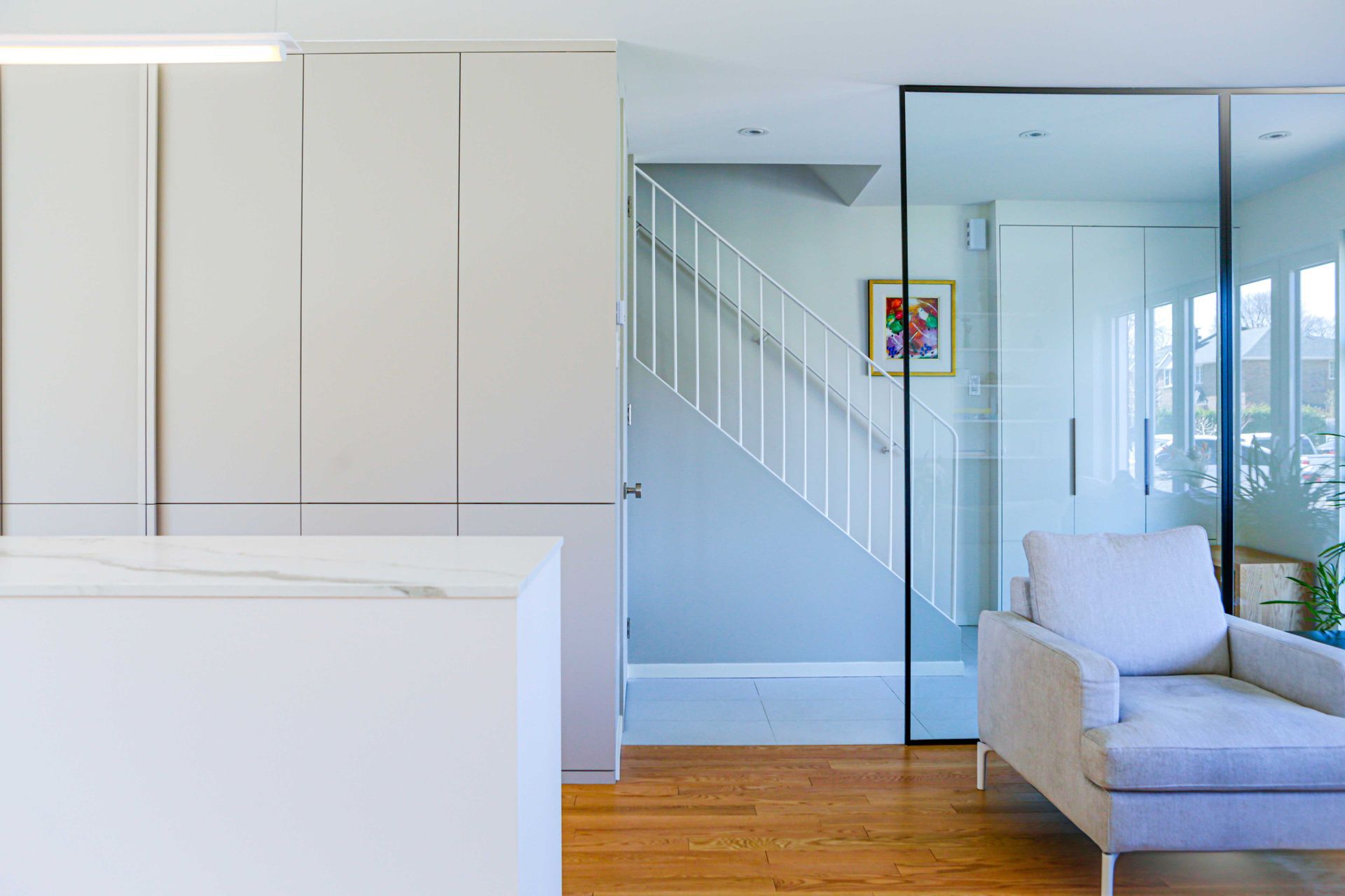 Un salon avec une chaise et un escalier en arrière-plan.