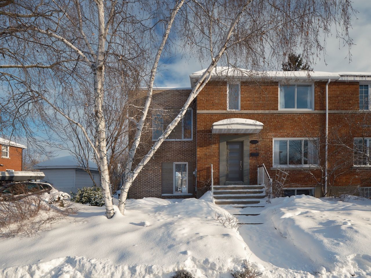 Une maison avec beaucoup de neige sur le sol devant elle