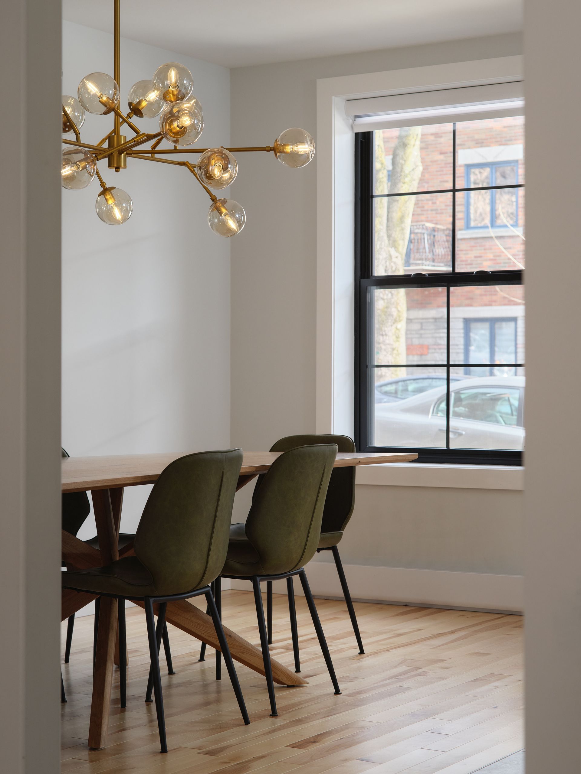 Une salle à manger avec une table et des chaises et une fenêtre.