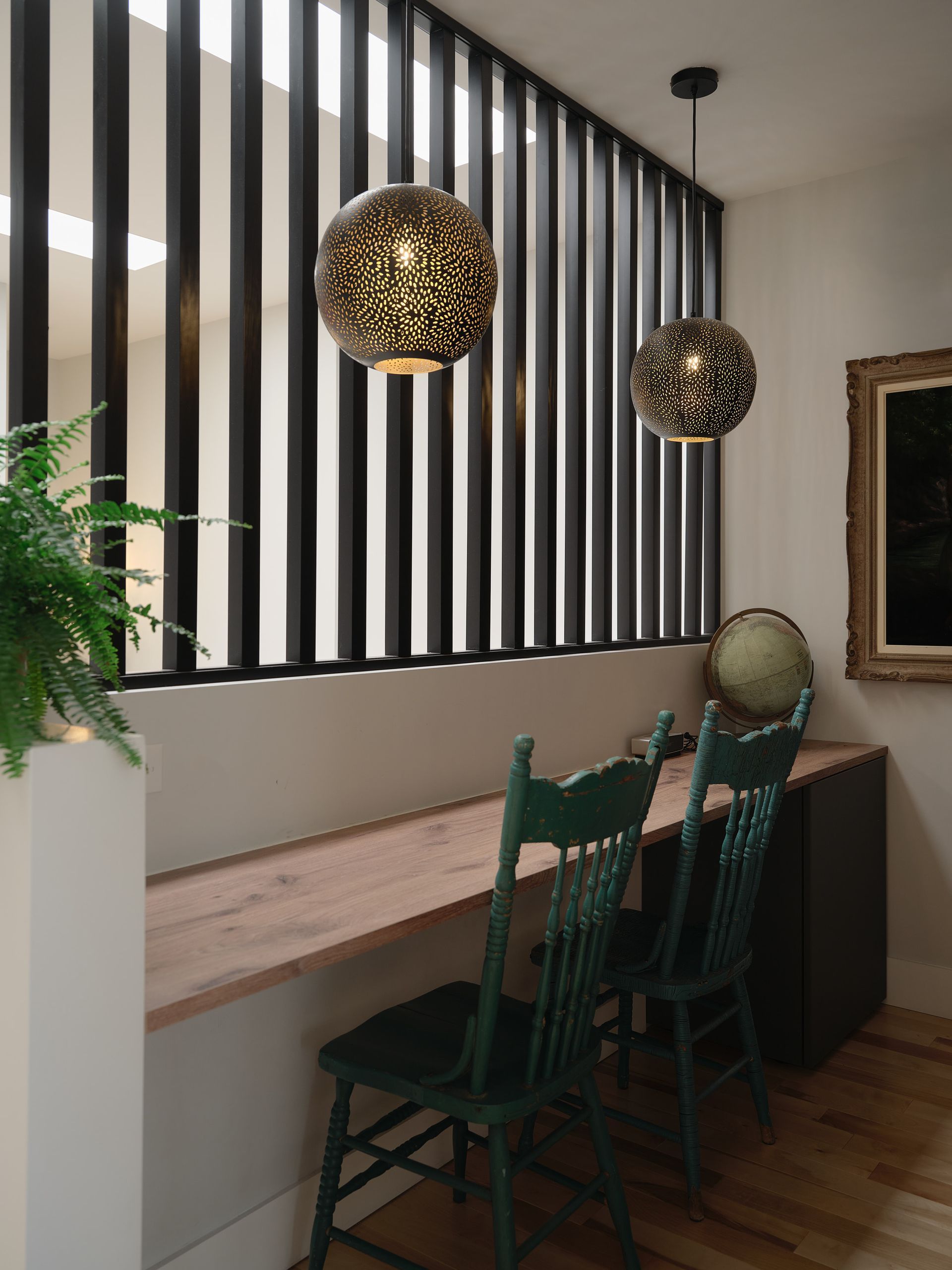 Une pièce avec une table et des chaises et un globe sur le mur.