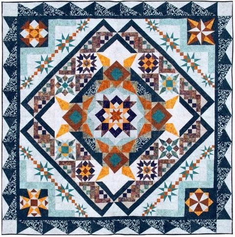 Geometric blue, orange, and white quilt with a starburst and diamond pattern