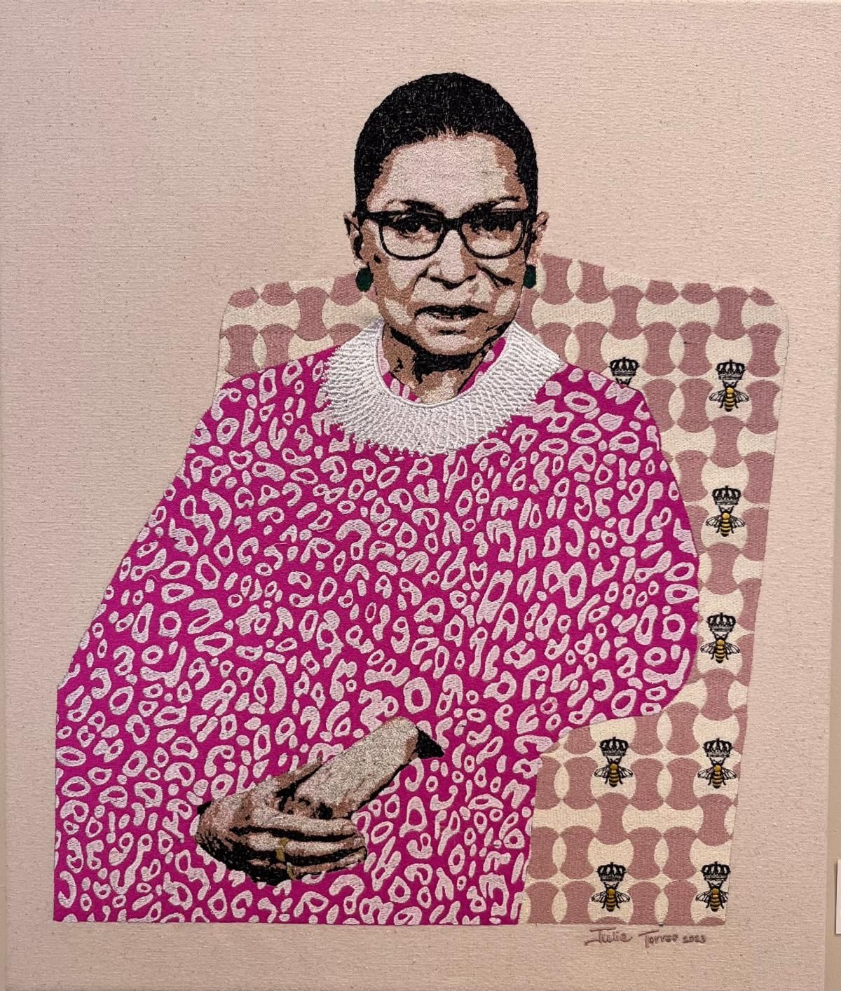 Woman in a pink patterned top holding a remote, seated against a beige patterned backdrop.