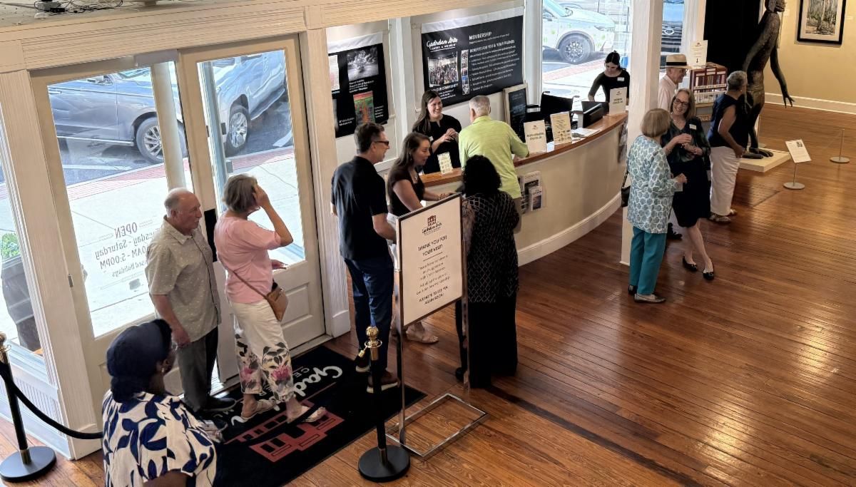 People standing in a bright café lobby near the counter and entrance.