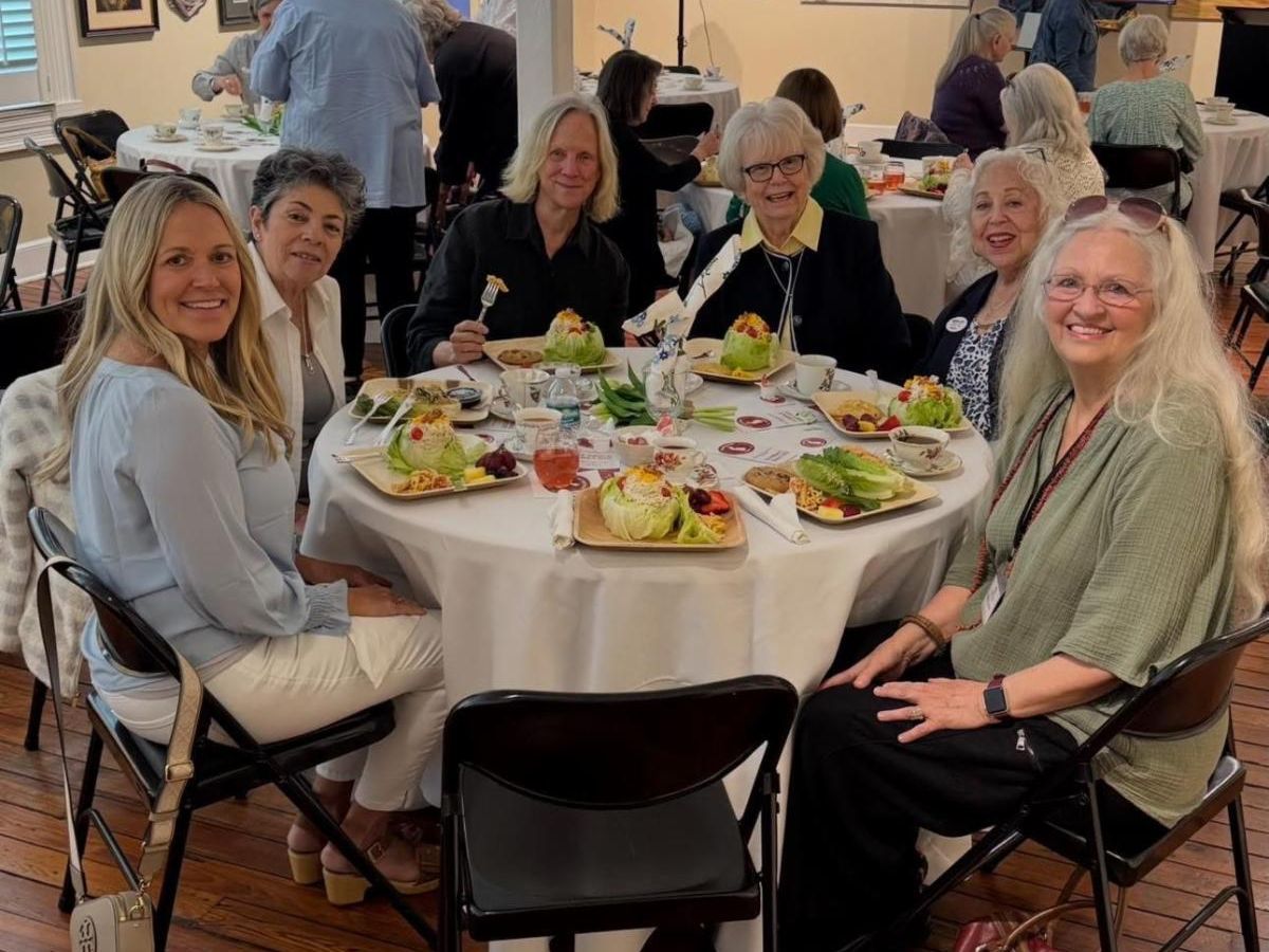 Group of friends seated around a dining table, sharing a meal in a cozy restaurant.