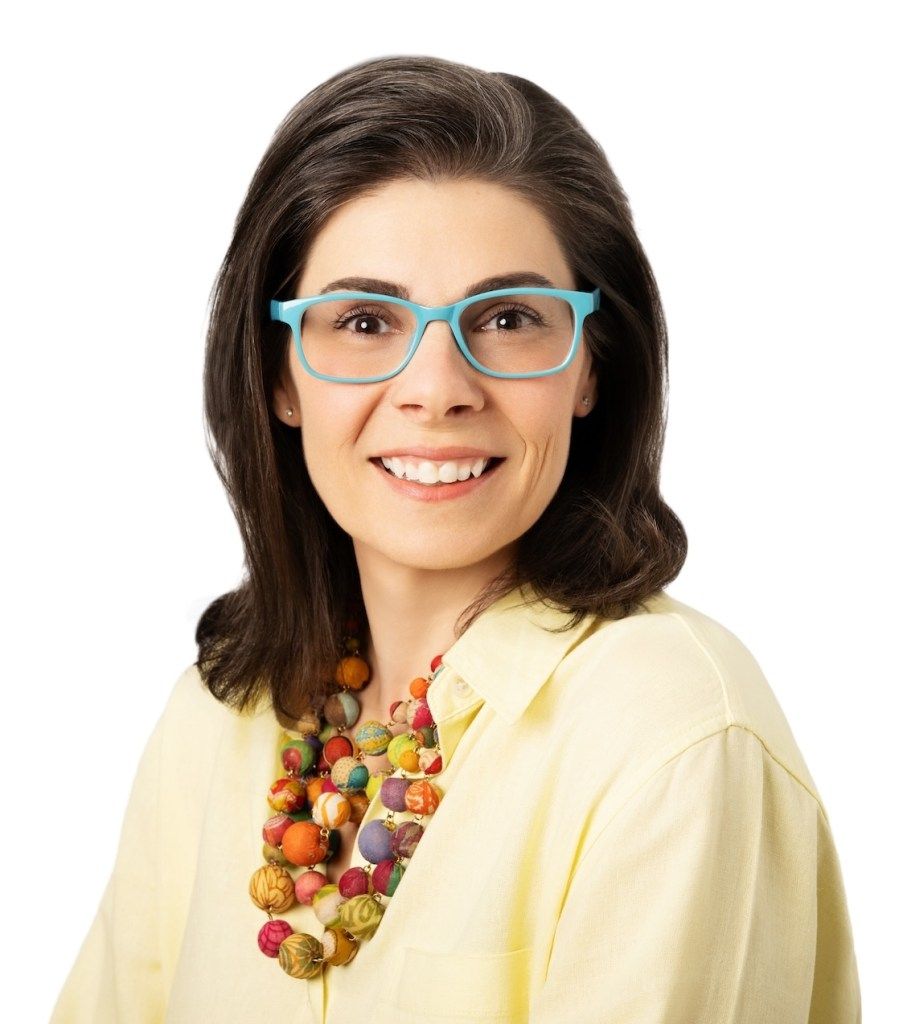 Smiling woman with blue glasses and colorful necklace on a white background