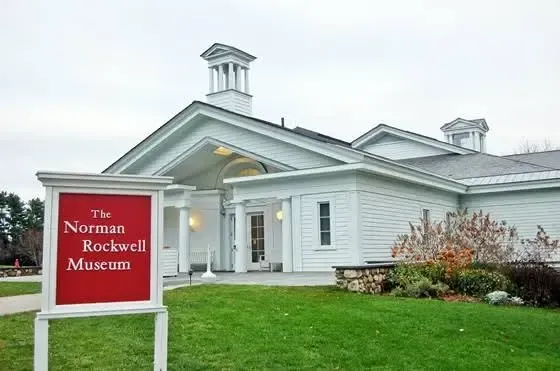 Norwalk Museum sign in front of a white historic building with green lawn