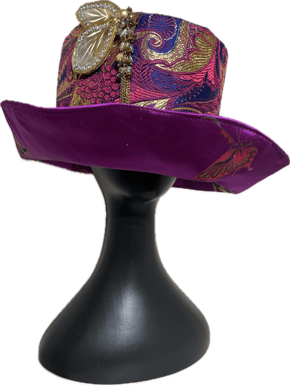 Decorative purple sequined hat with gold accents on a black display stand