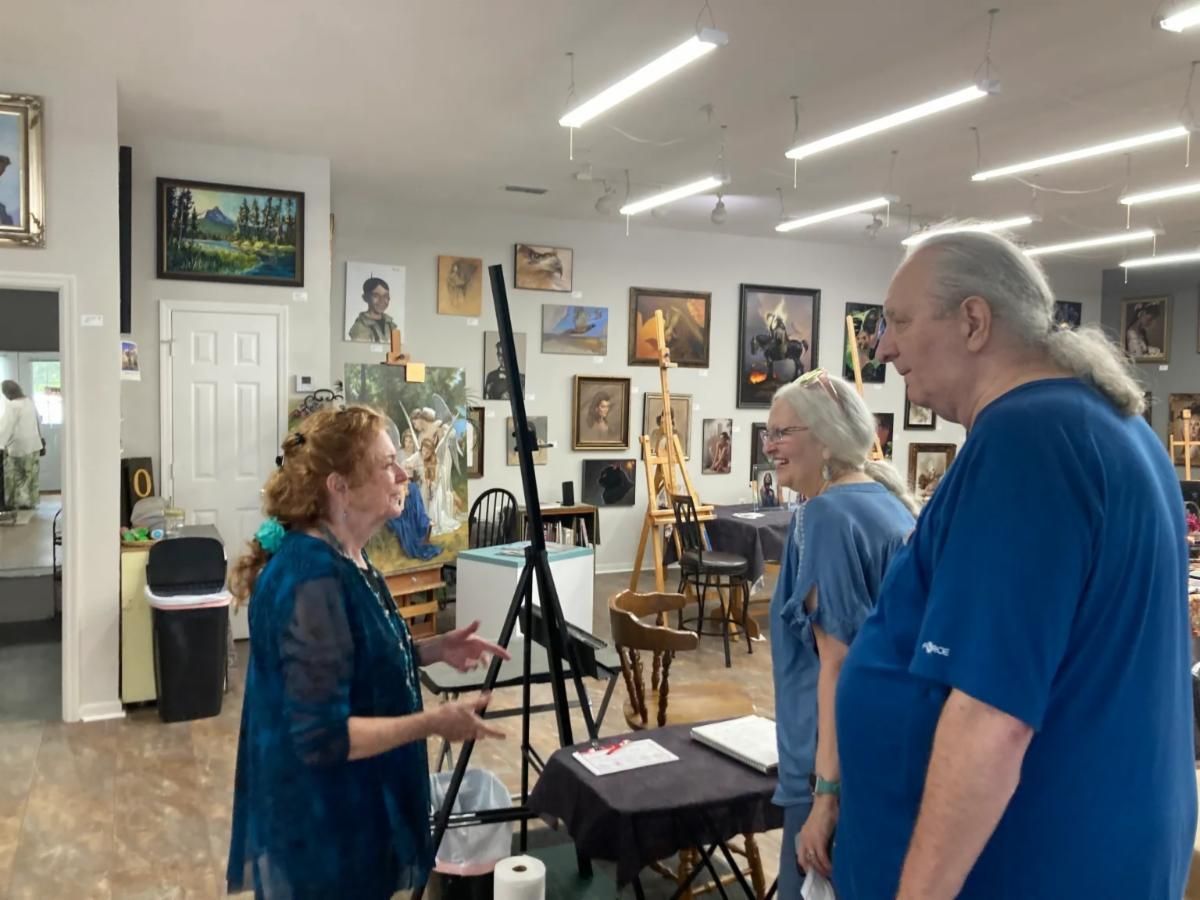 People talking in an art studio with paintings on the walls and easels around them.