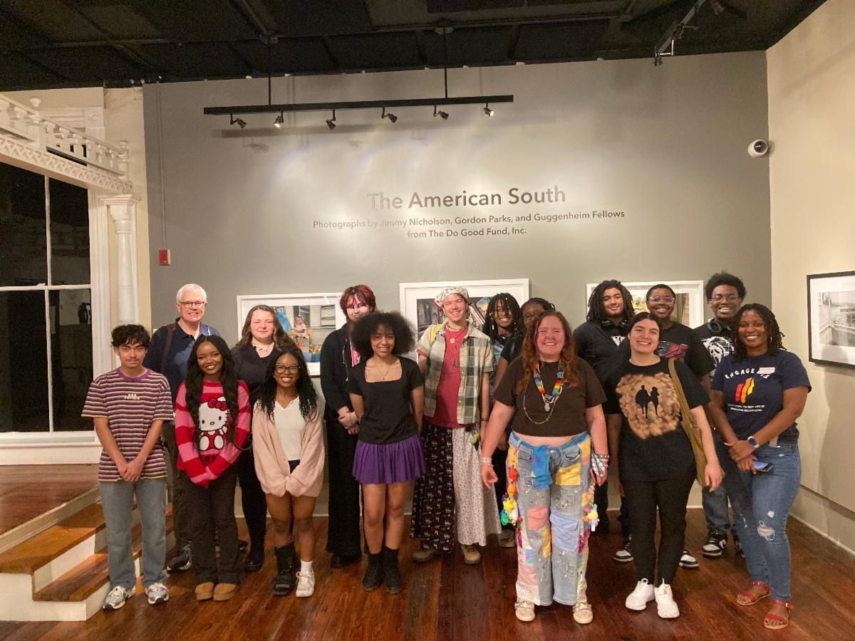 Group of people posing in a gallery before a wall reading “The American South.”
