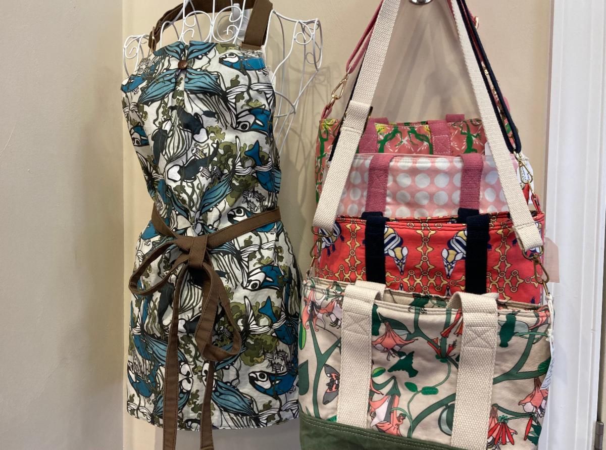 Two patterned fabric hanging organizers with bows, one blue and one pink, on a wall