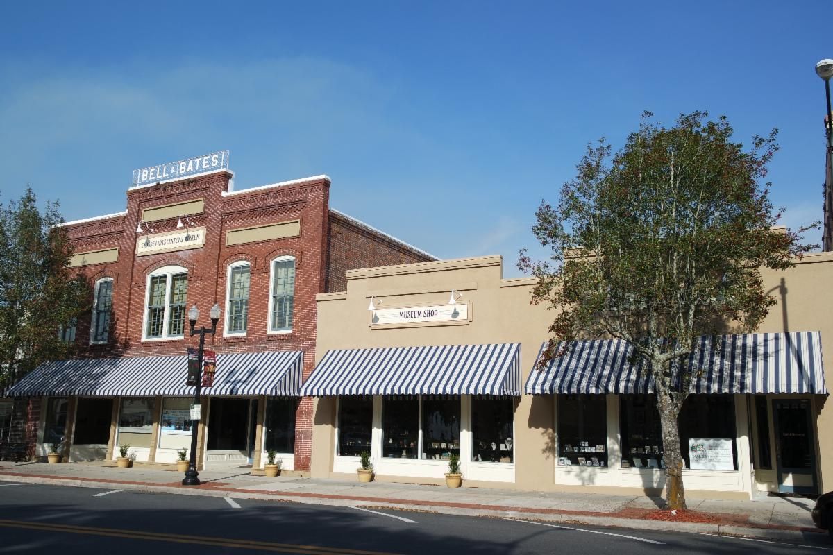 Historic brick storefronts with striped awnings on a sunny street corner