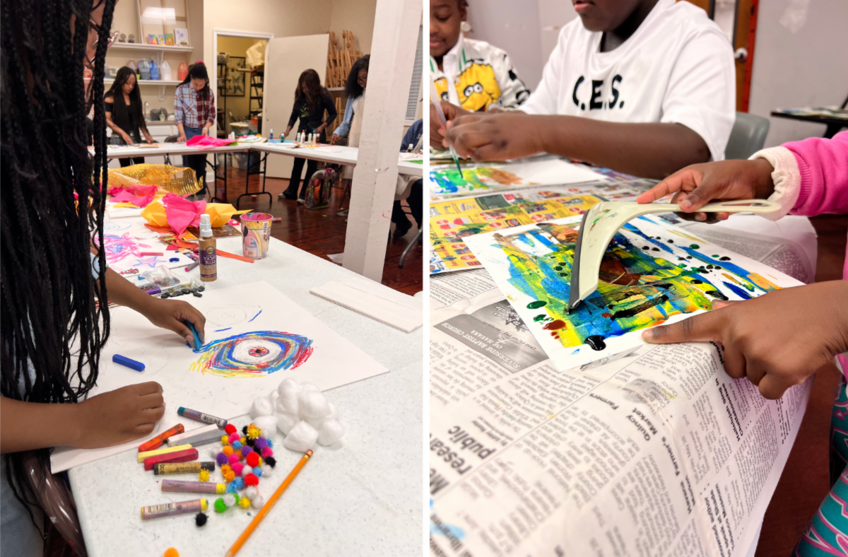 People painting colorful art on paper at a table in a bright studio.