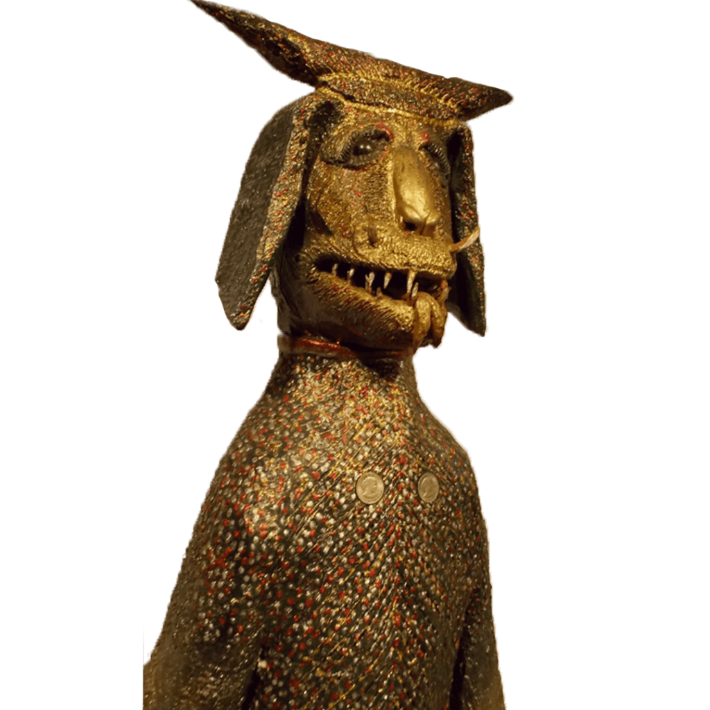 Gold-toned abstract sculpture with a goat-like head and patterned torso on a white background