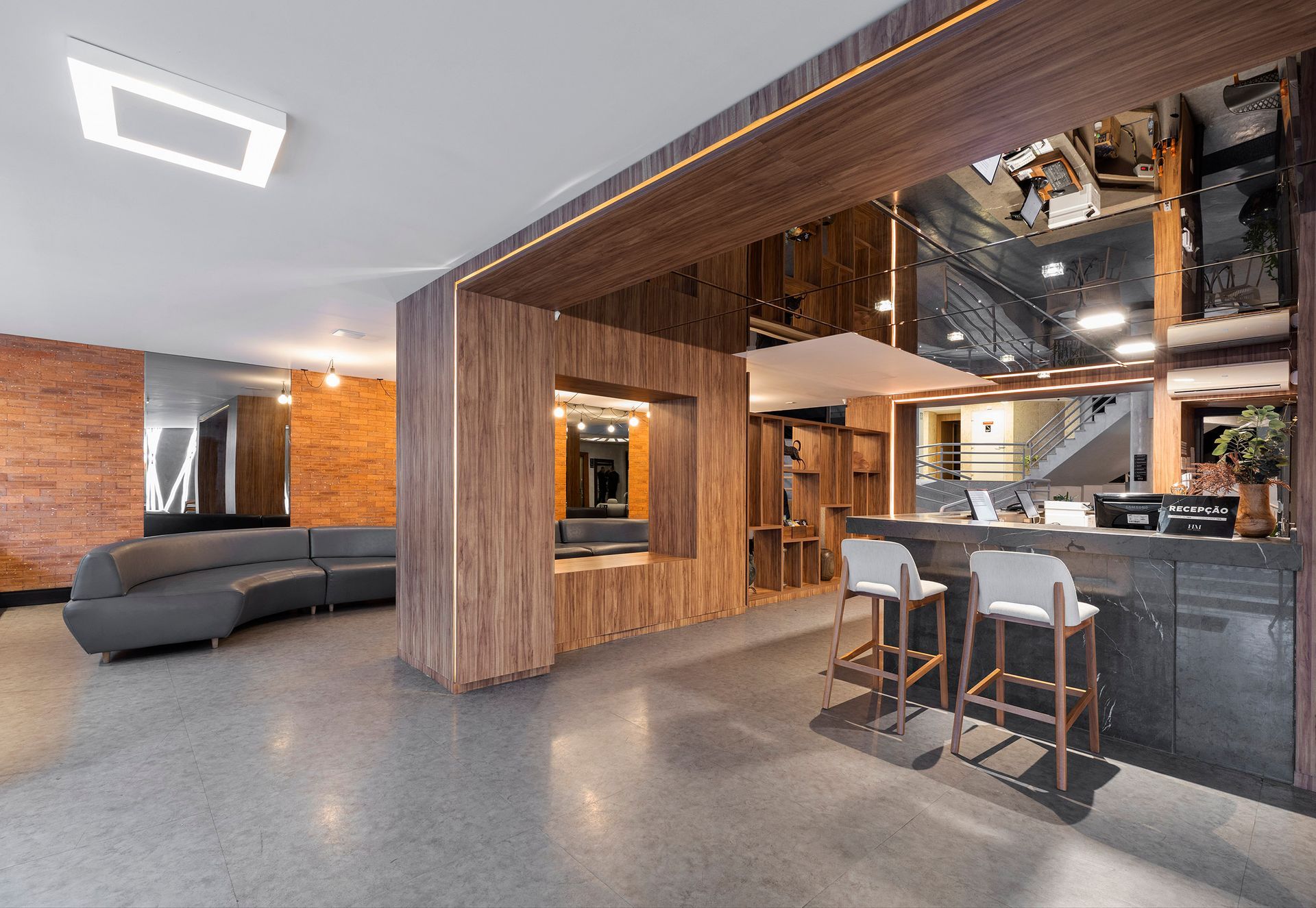 Loft moderno em conceito aberto, com painéis de madeira, assentos cinza, ilha de cozinha e piso de concreto polido