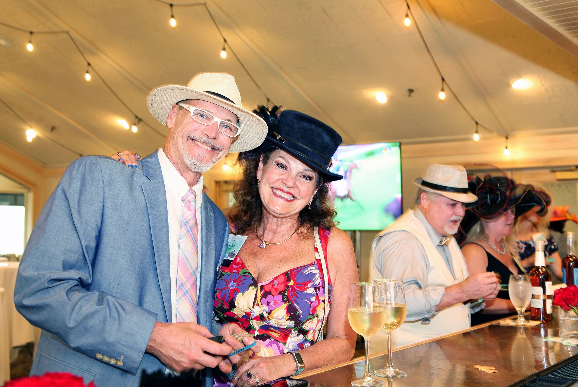 A man and a woman are standing next to each other at a bar.