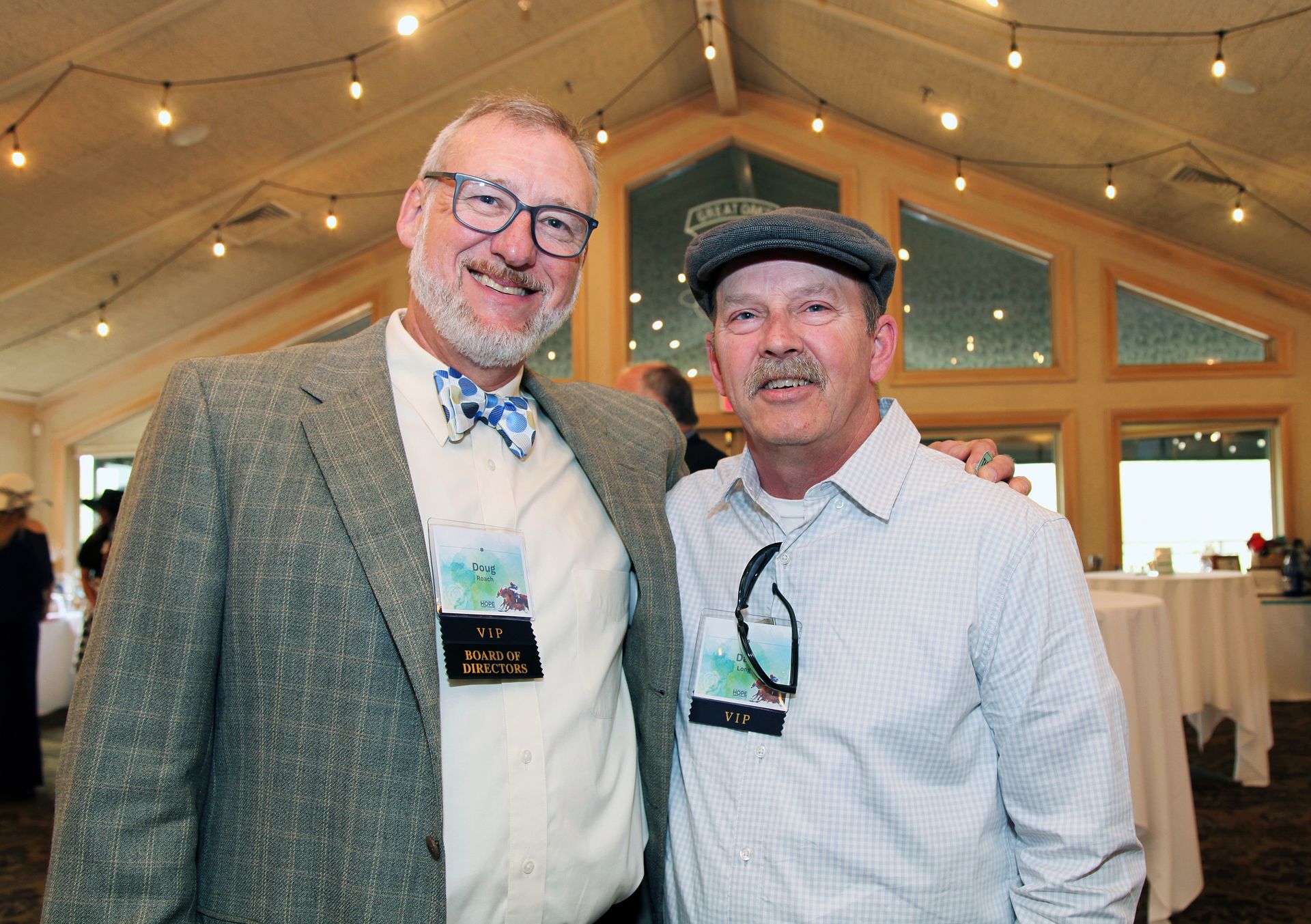 Two men are posing for a picture together in a room.