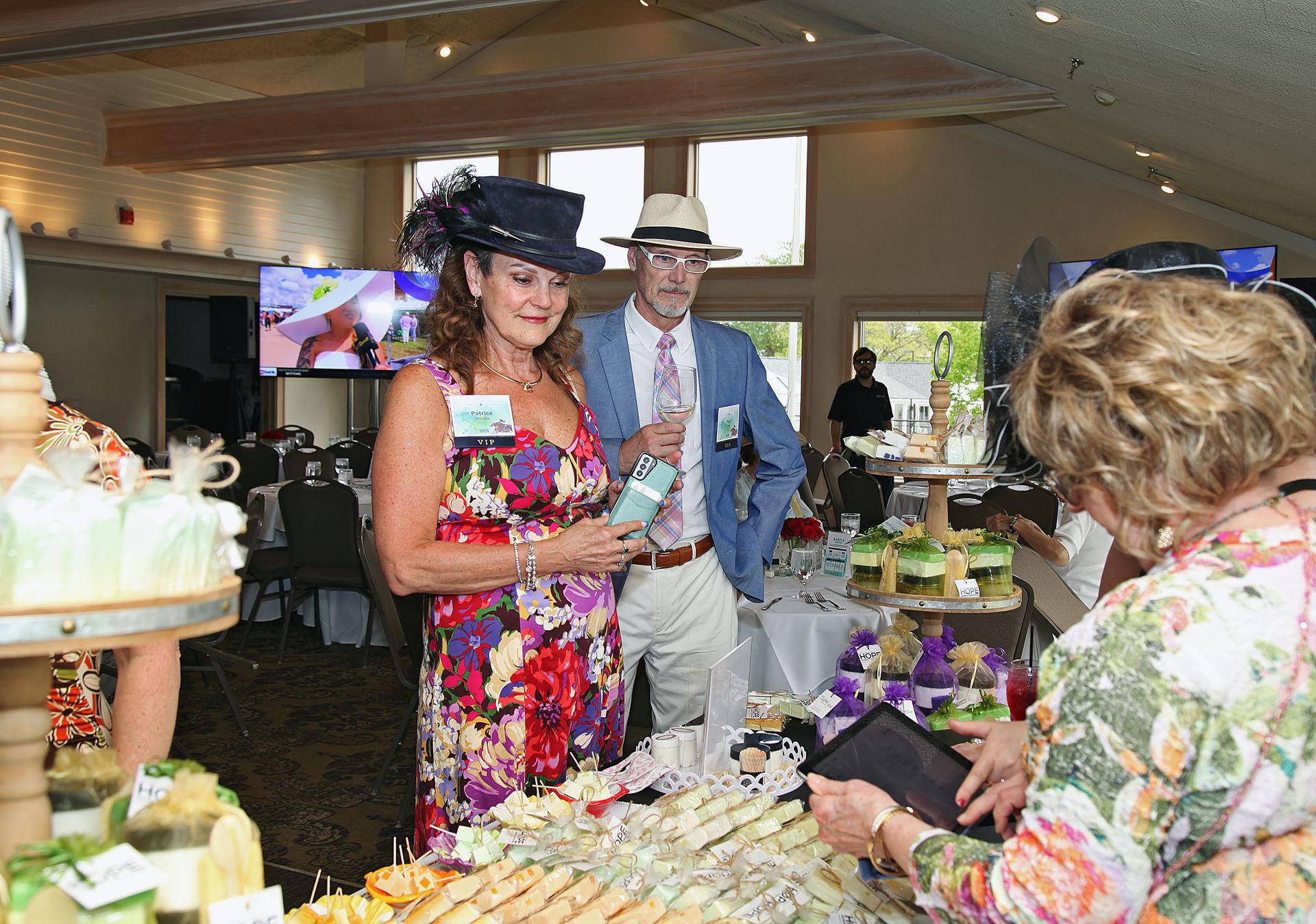 A group of people are standing around a table with food.