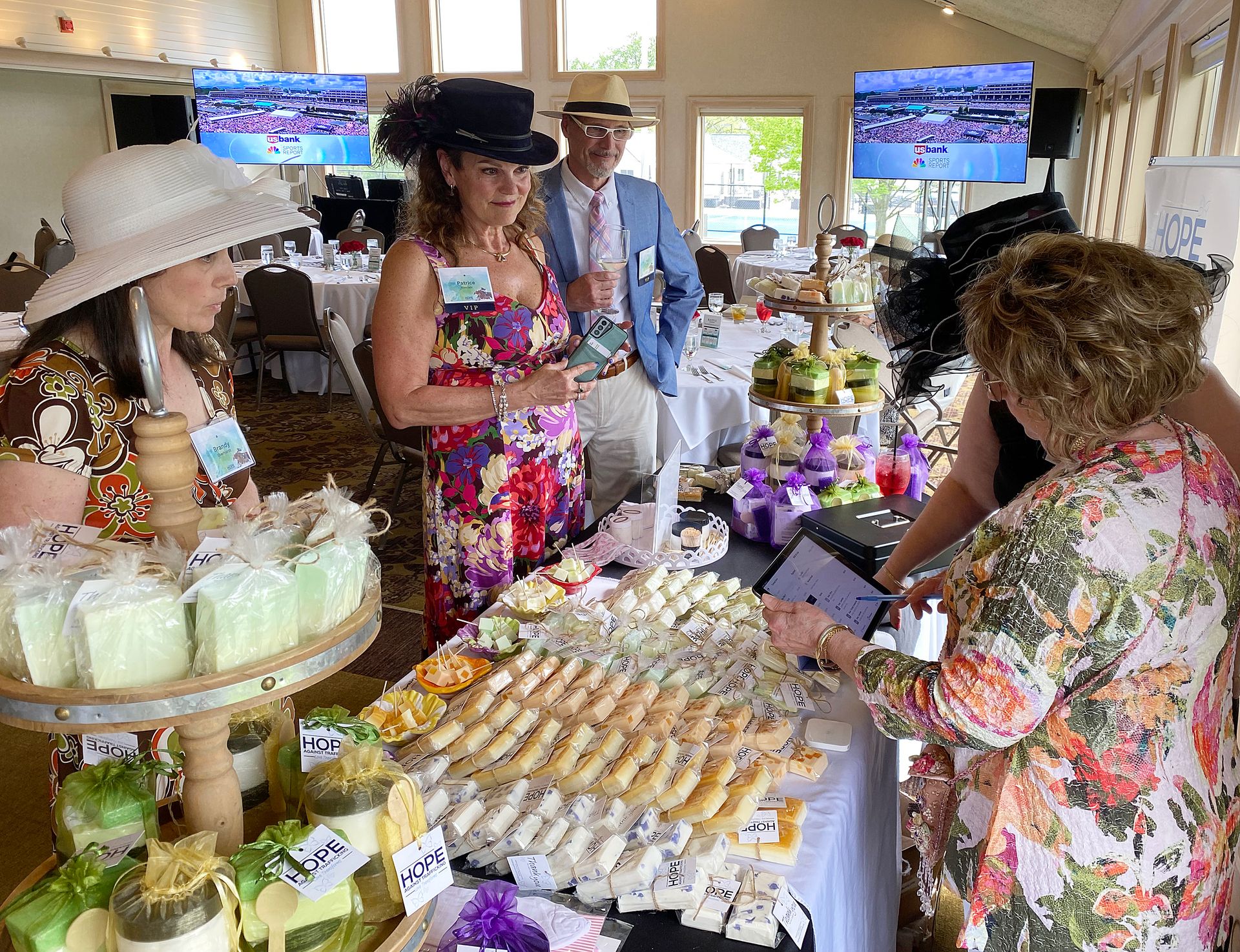 A group of people are standing around a table filled with food.