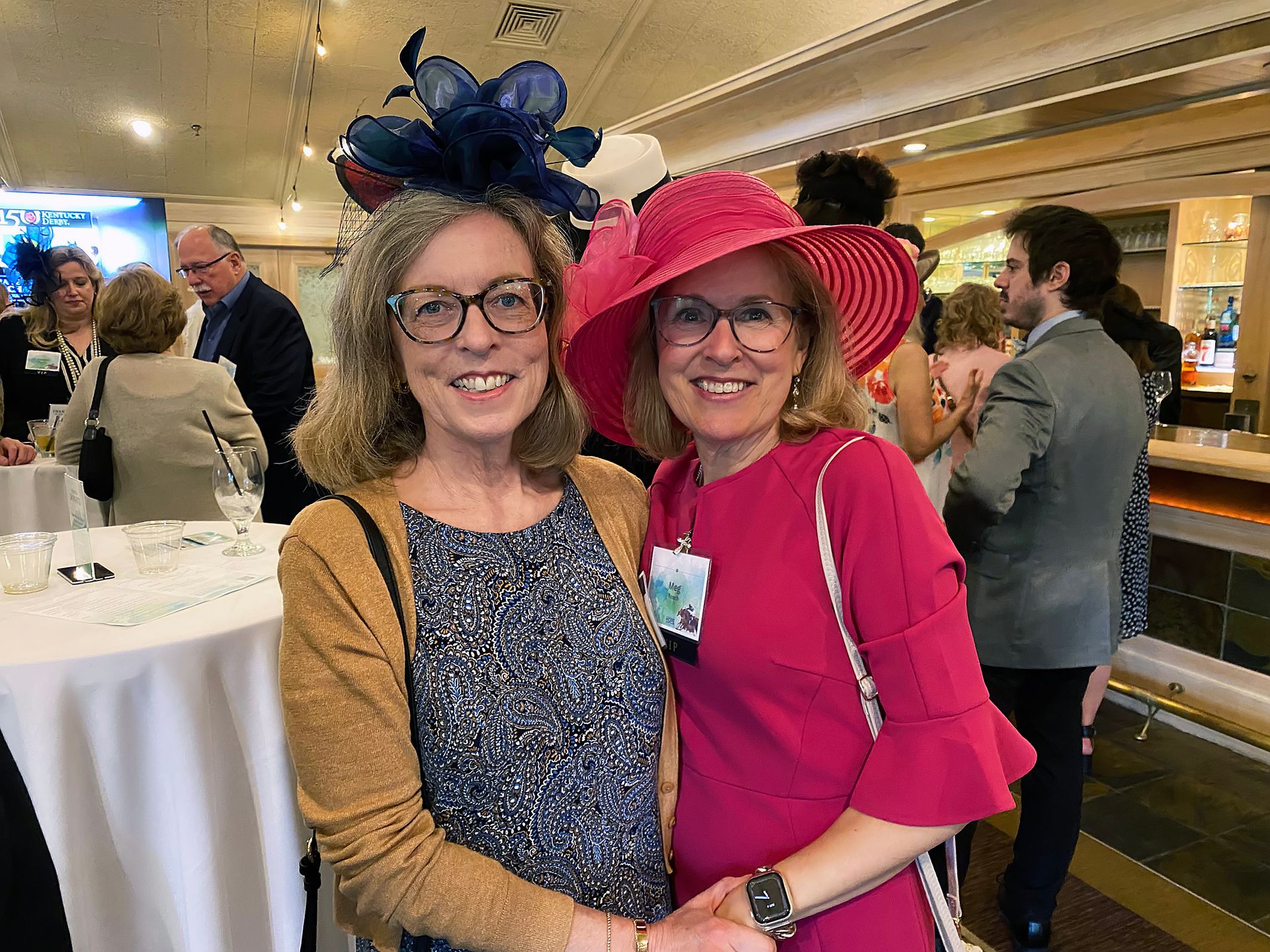 Two women wearing hats and glasses are posing for a picture.