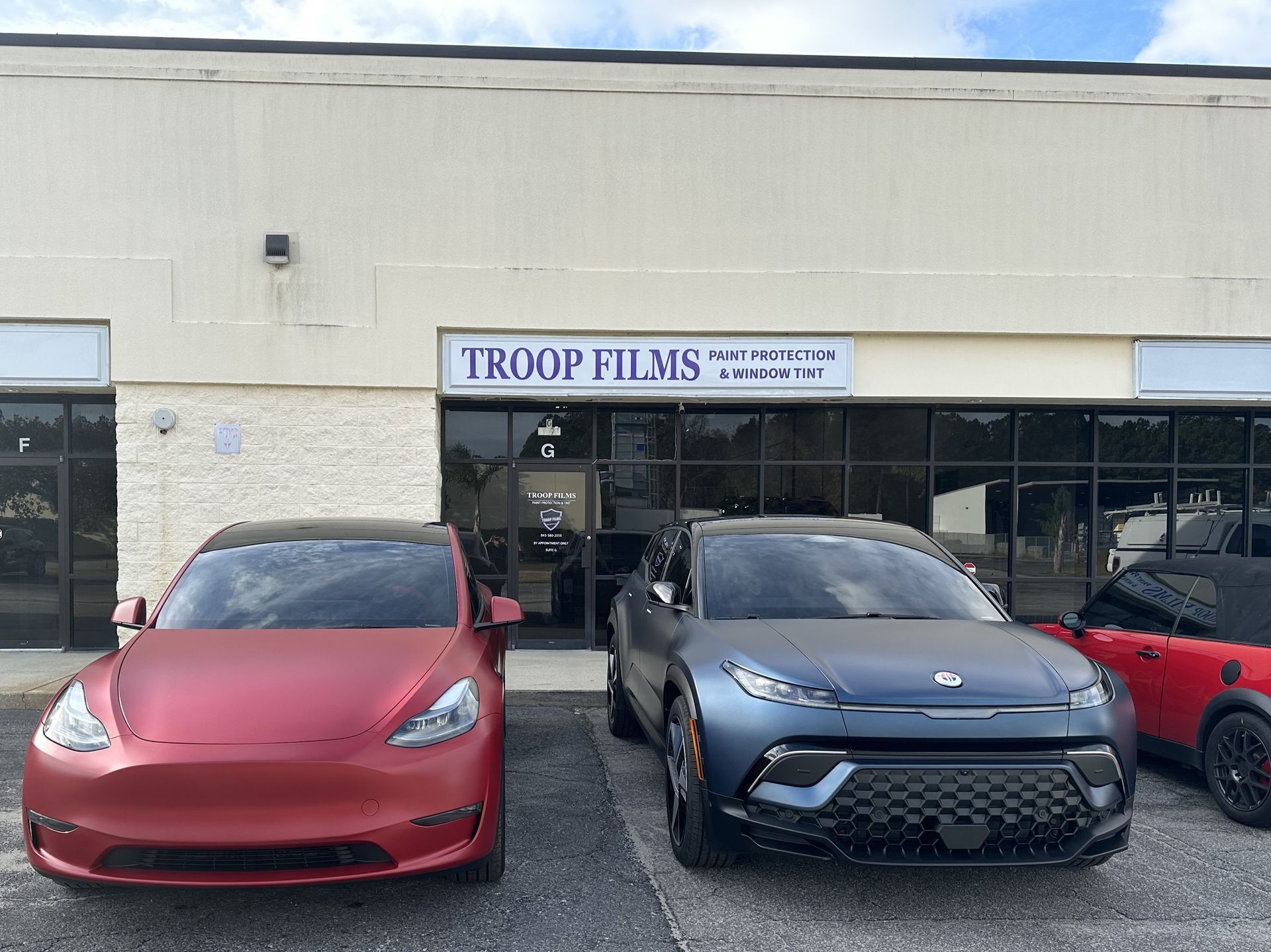 three cars are parked in front of a building .