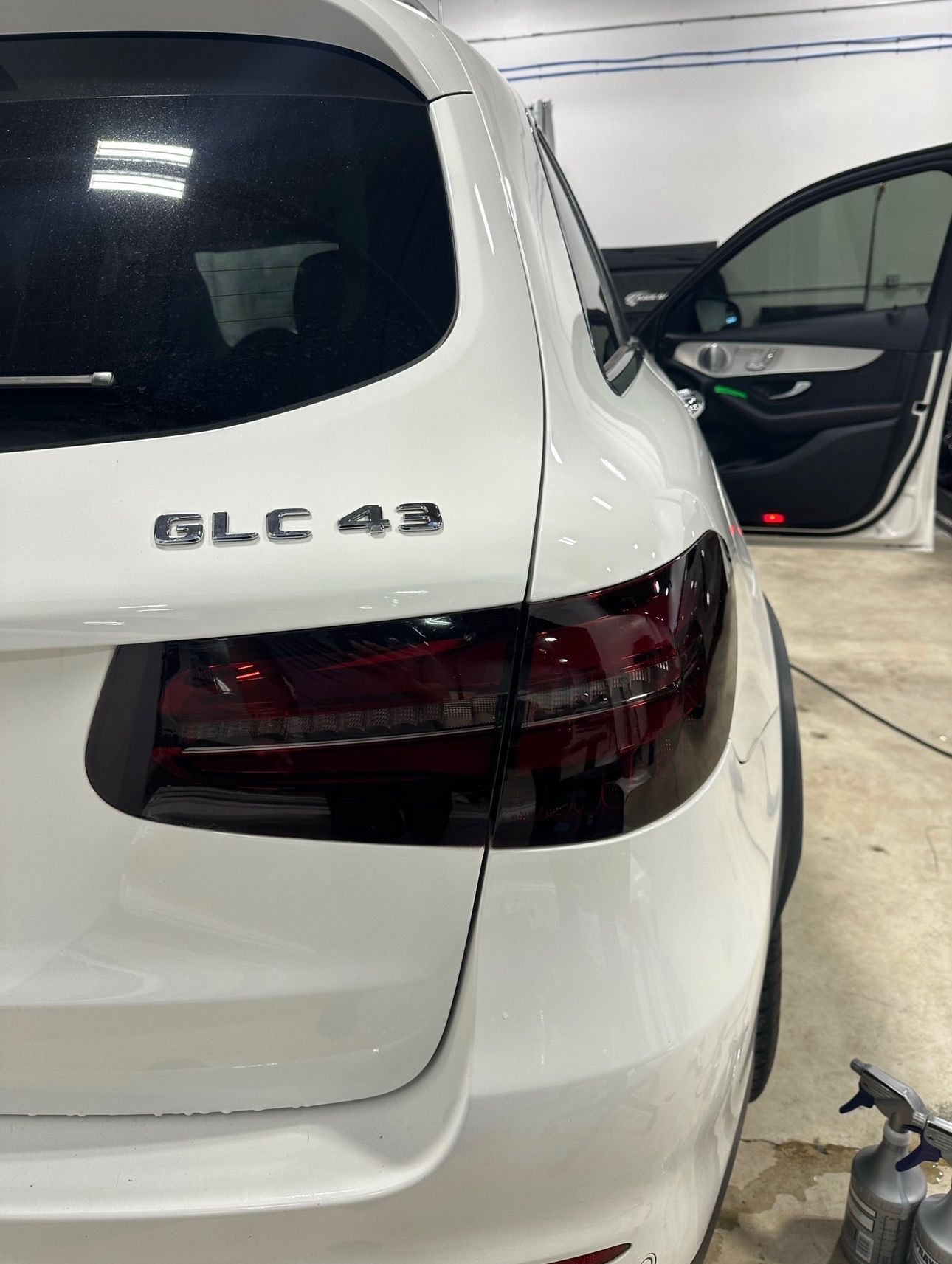 a white mercedes benz glc 43 is sitting in a garage .
