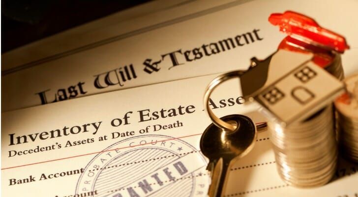 A stack of coins sits on top of a last will and testament