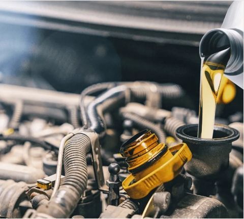 Fresh engine oil being poured into a car motor