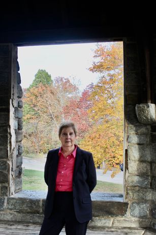 Dr. Leslie Gruis in a business suit in a stone doorway