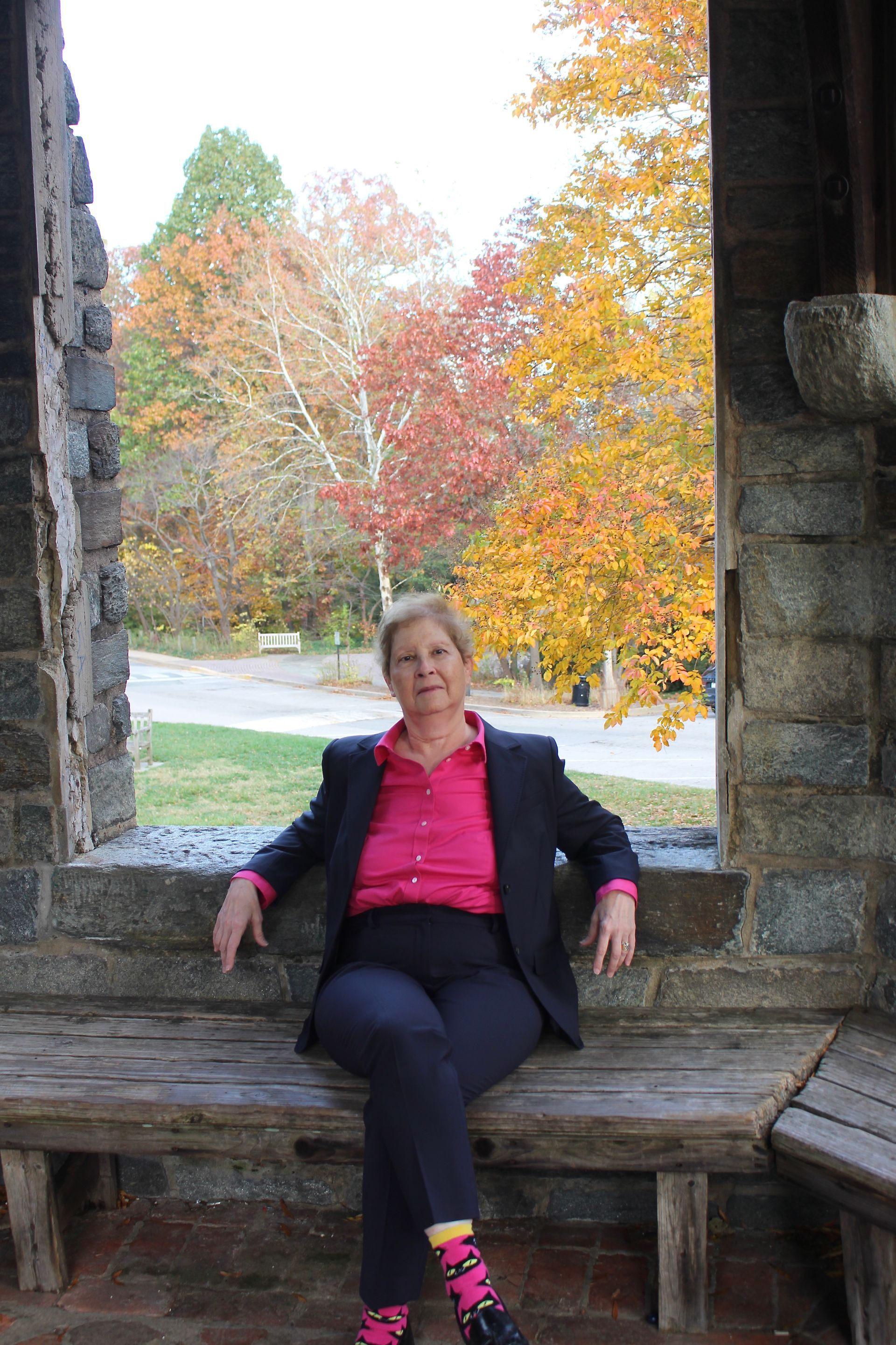 Dr. Leslie Gruis sitting on stone bench