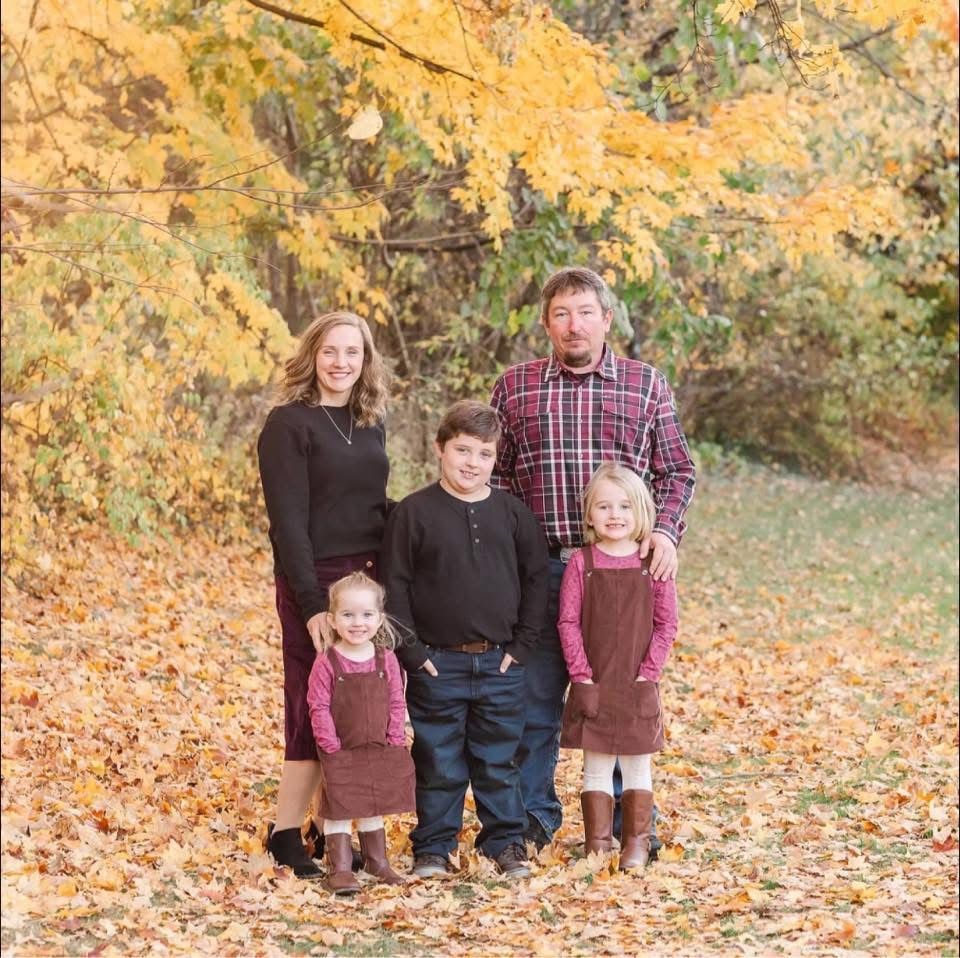 The Vickers family and R.Work Excavating & Trucking owner Matt Vickers posing for a picture in a field of leaves.