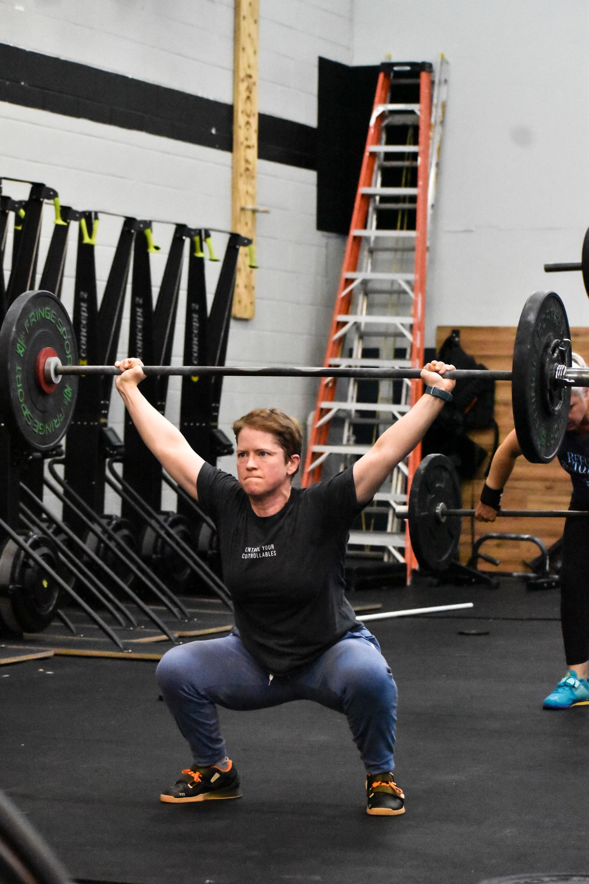 Member doing an overhead squat during class.