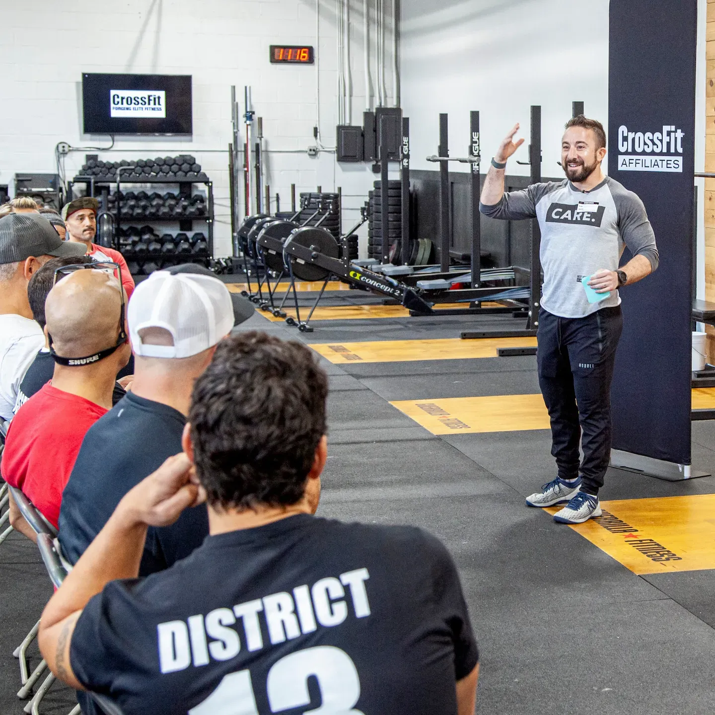 A man in a district 12 shirt stands in front of a group of people