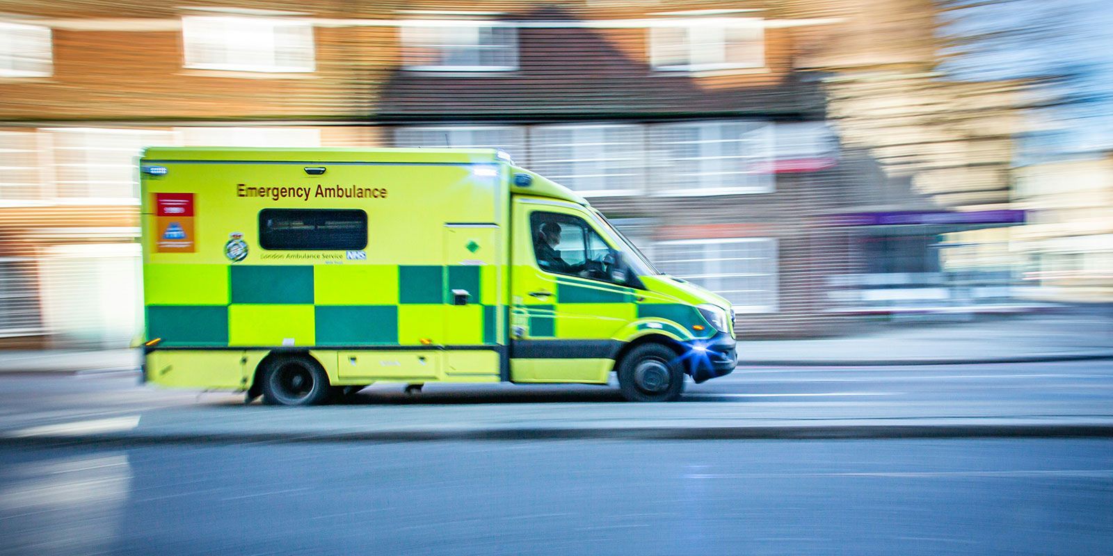 Ambulance racing at high speed through a town