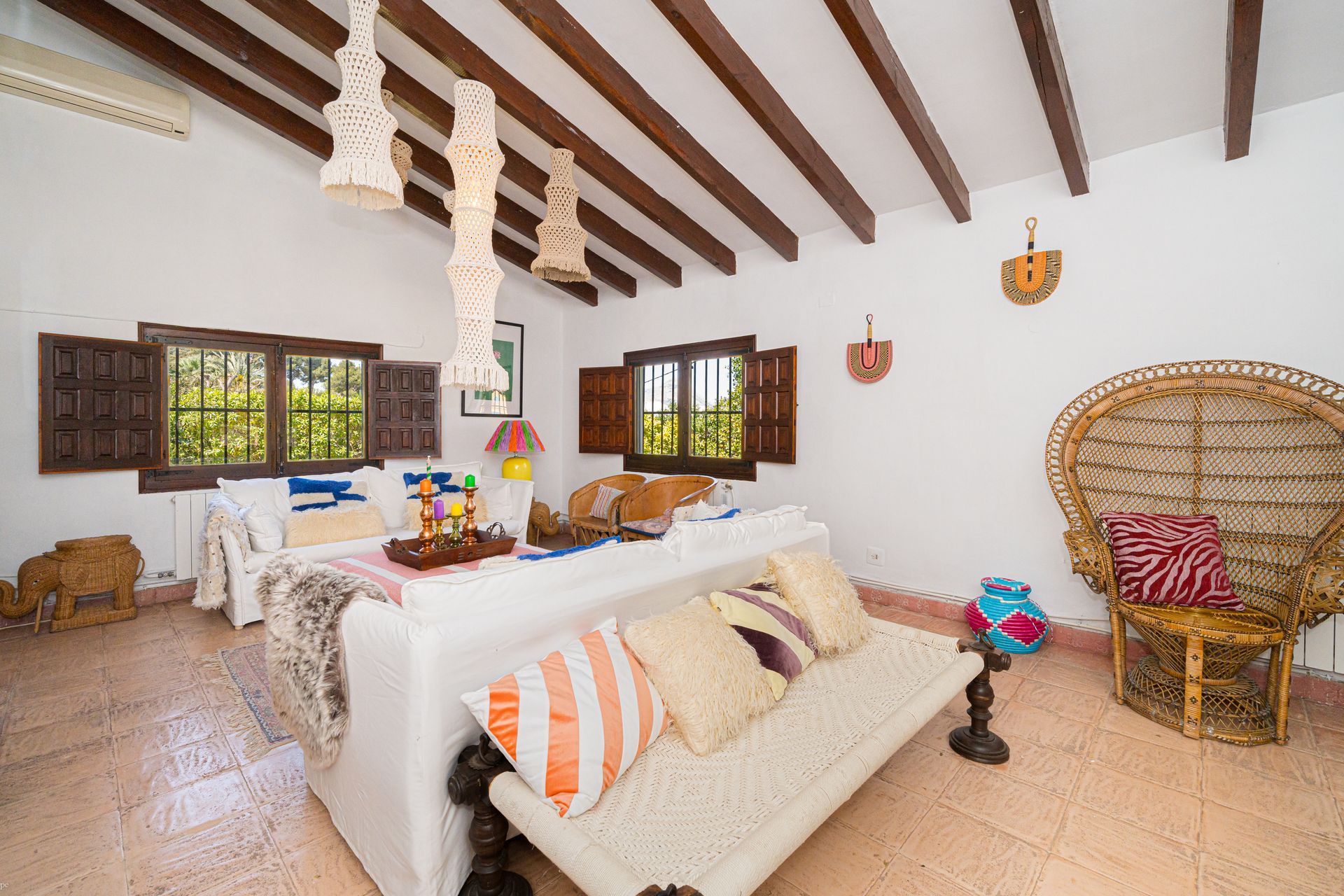 Een woonkamer met een witte bank en rieten stoelen van Villa Fave, El Tosalet, Javea