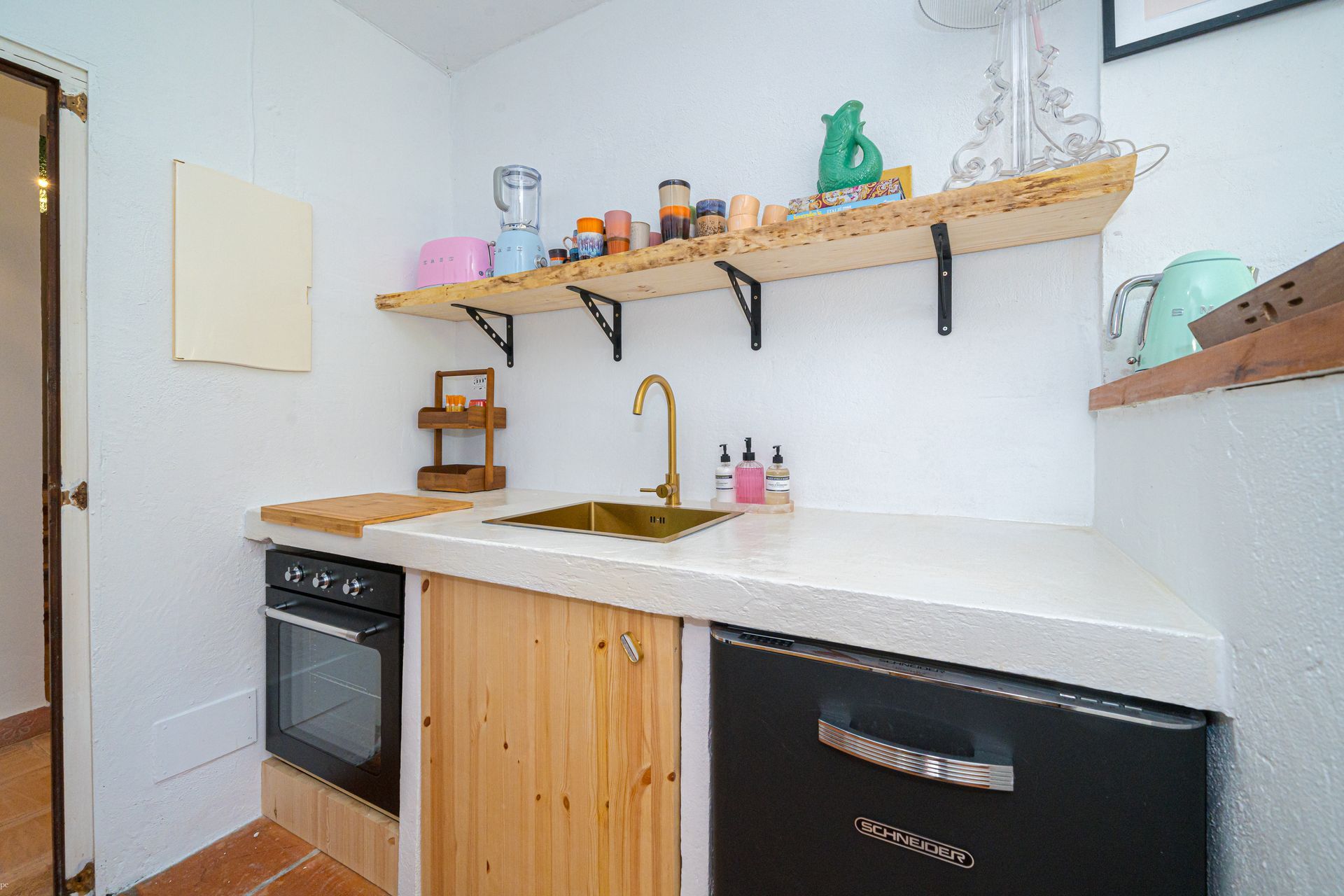 Een keuken met houten kasten en een zwarte vaatwasser