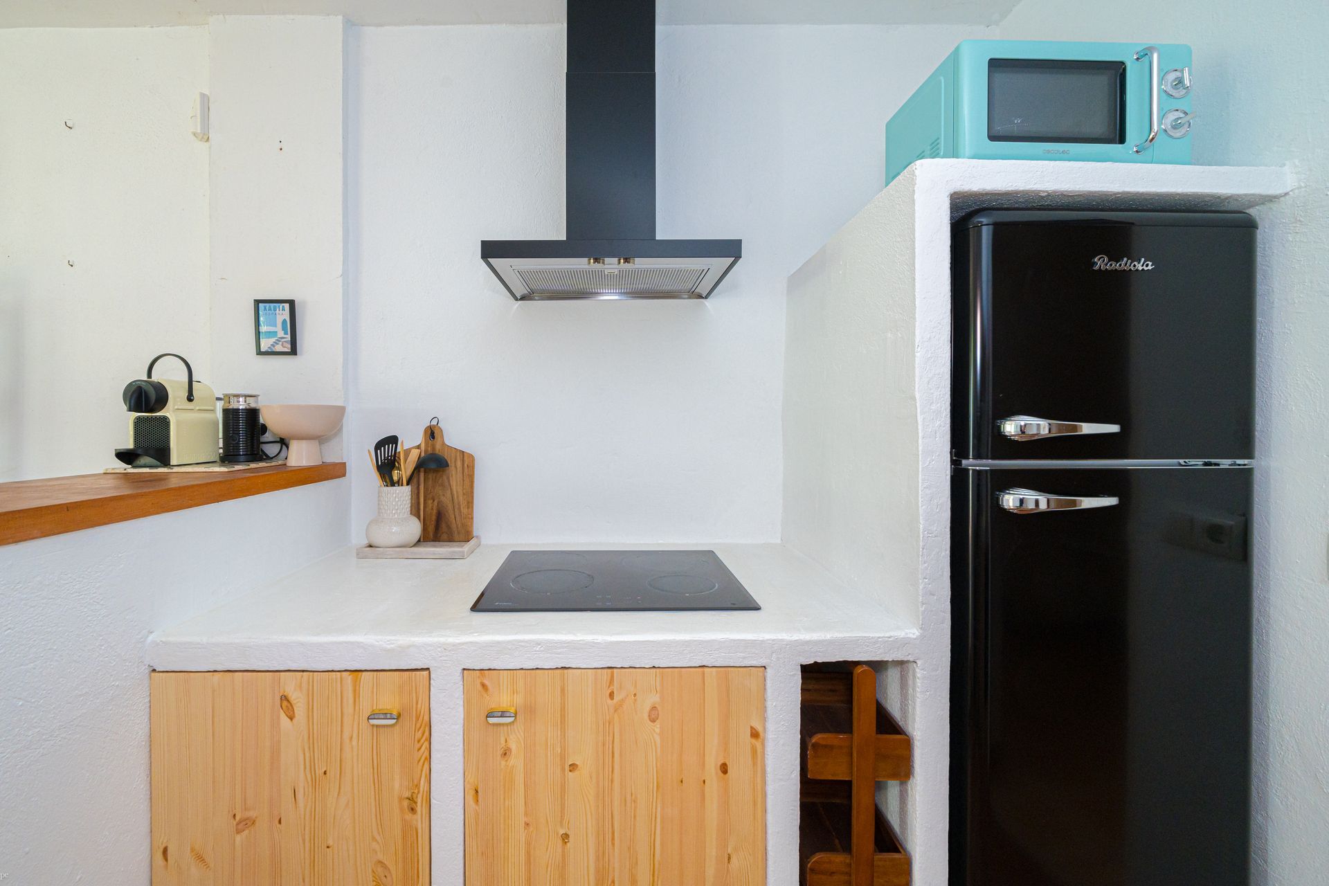 Een keuken met een zwarte koelkast en een blauwe magnetron van Villa Fave, El Tosalet, Javea