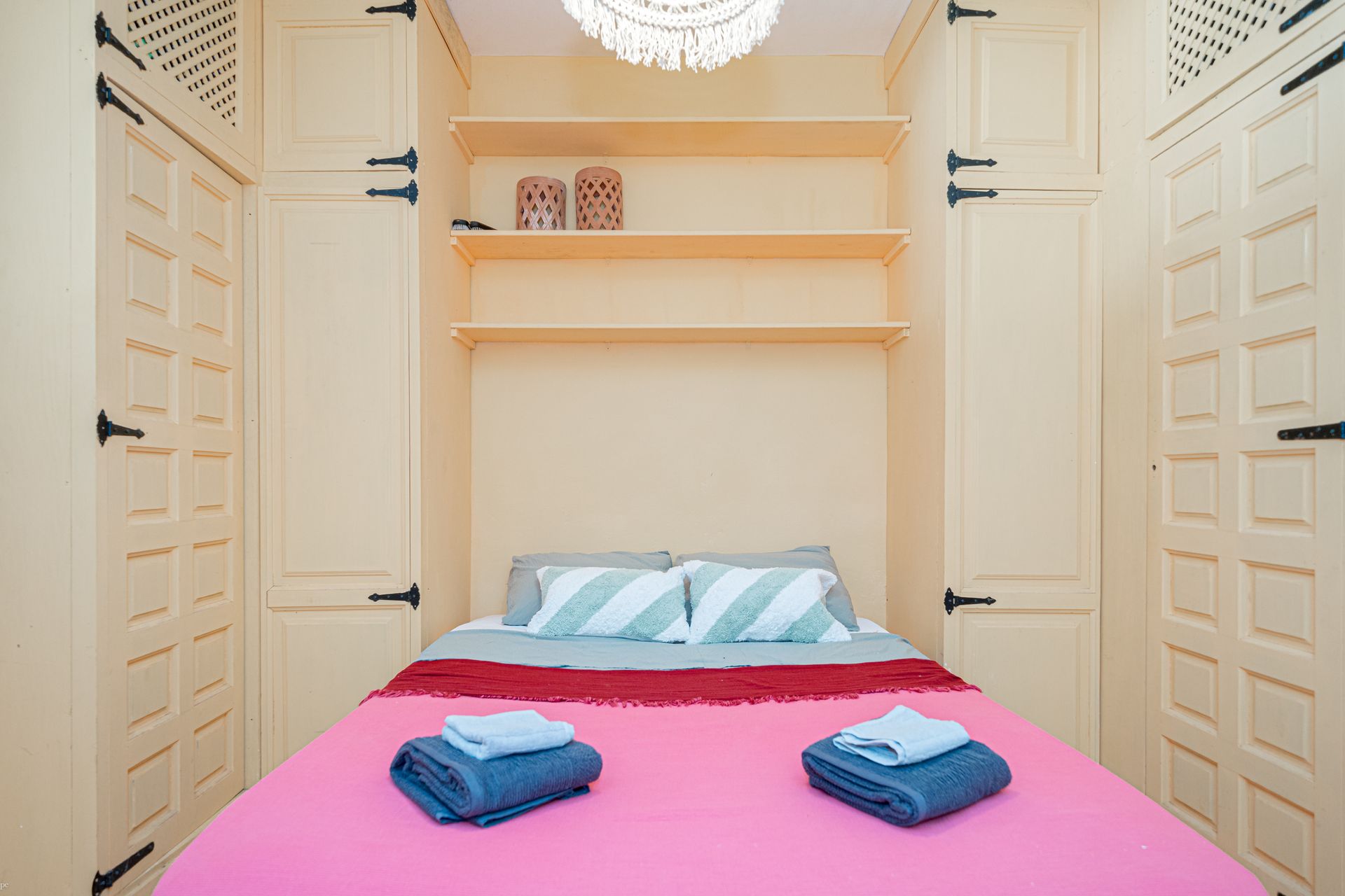 Een slaapkamer met een roze bed en blauwe handdoeken erop van Villa Fave in Javea