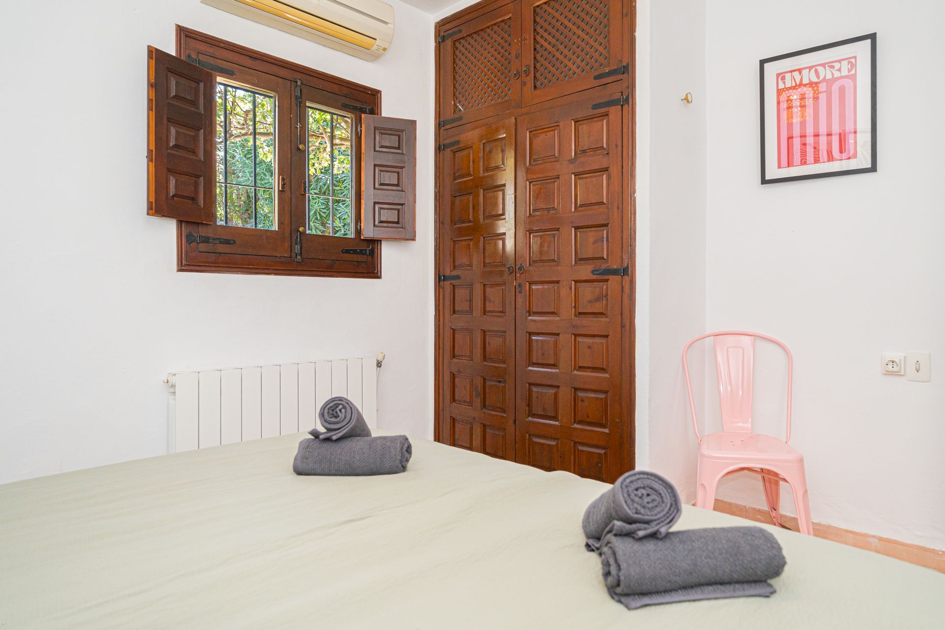 Een slaapkamer met een roze stoel en een foto aan de muur met de tekst rio van Villa Fave 